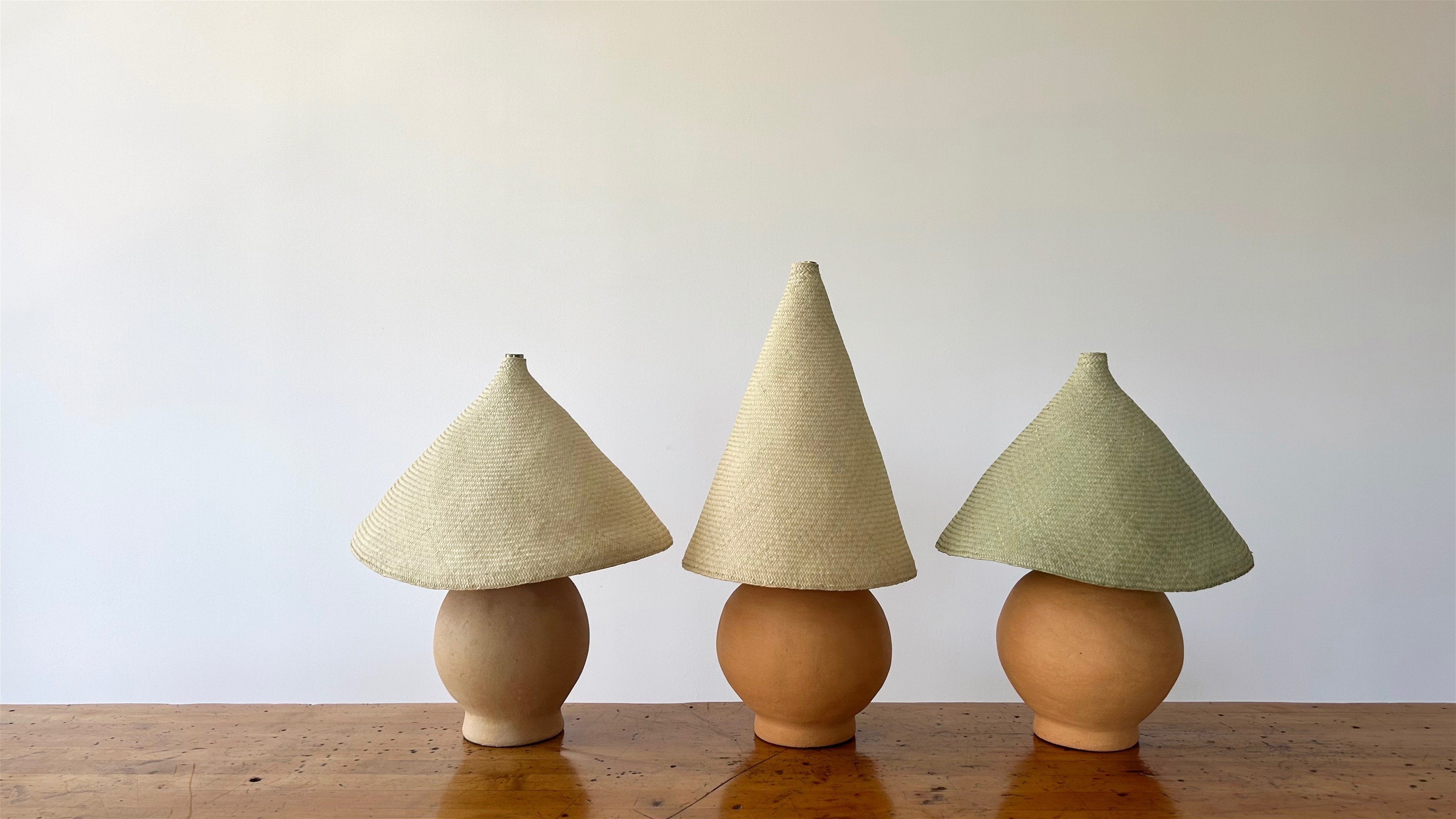 three small vases with hats on them on a table