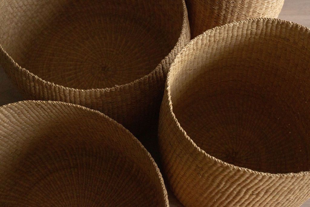 four woven baskets sitting on top of a wooden table