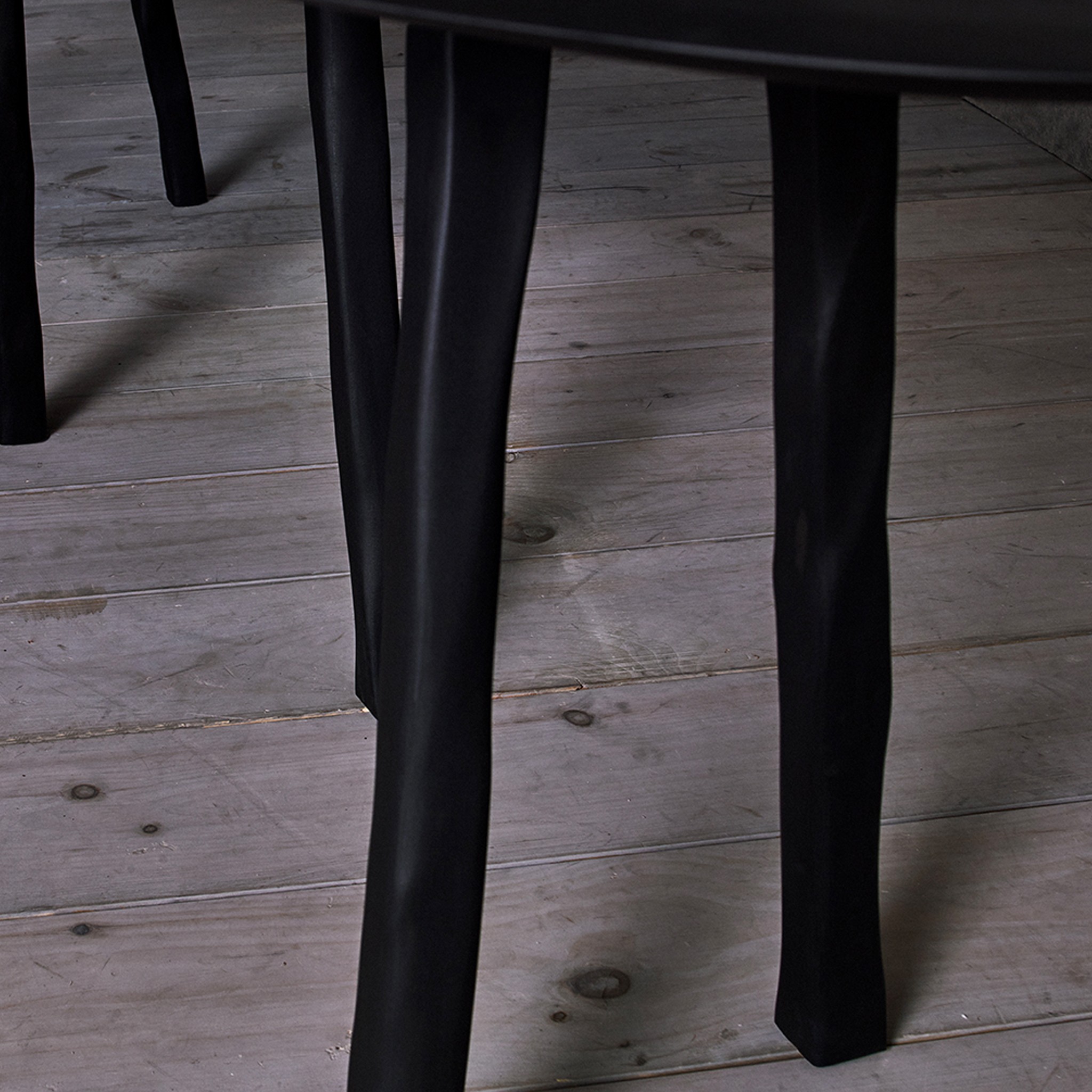 a close up of a black chair on a wooden floor