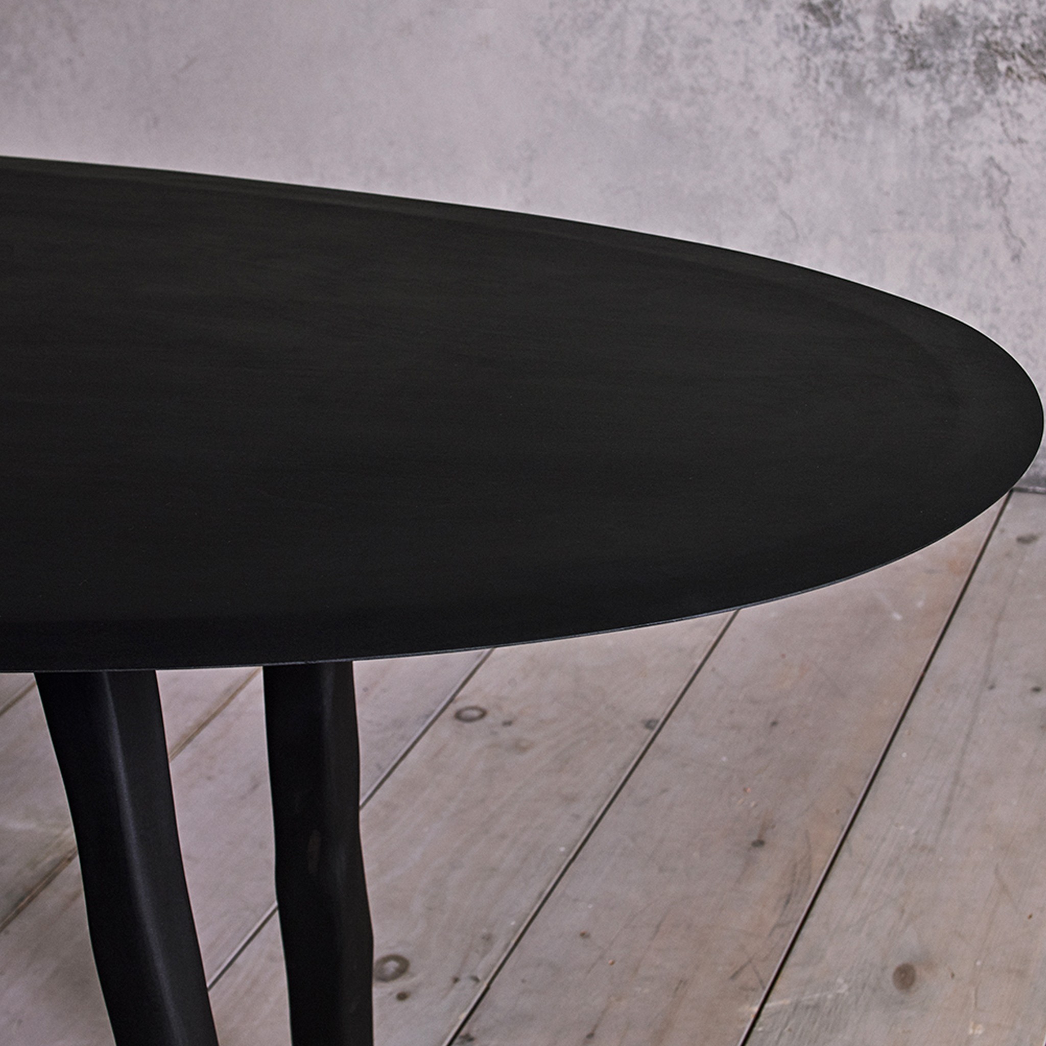 a table with a black top on a wooden floor