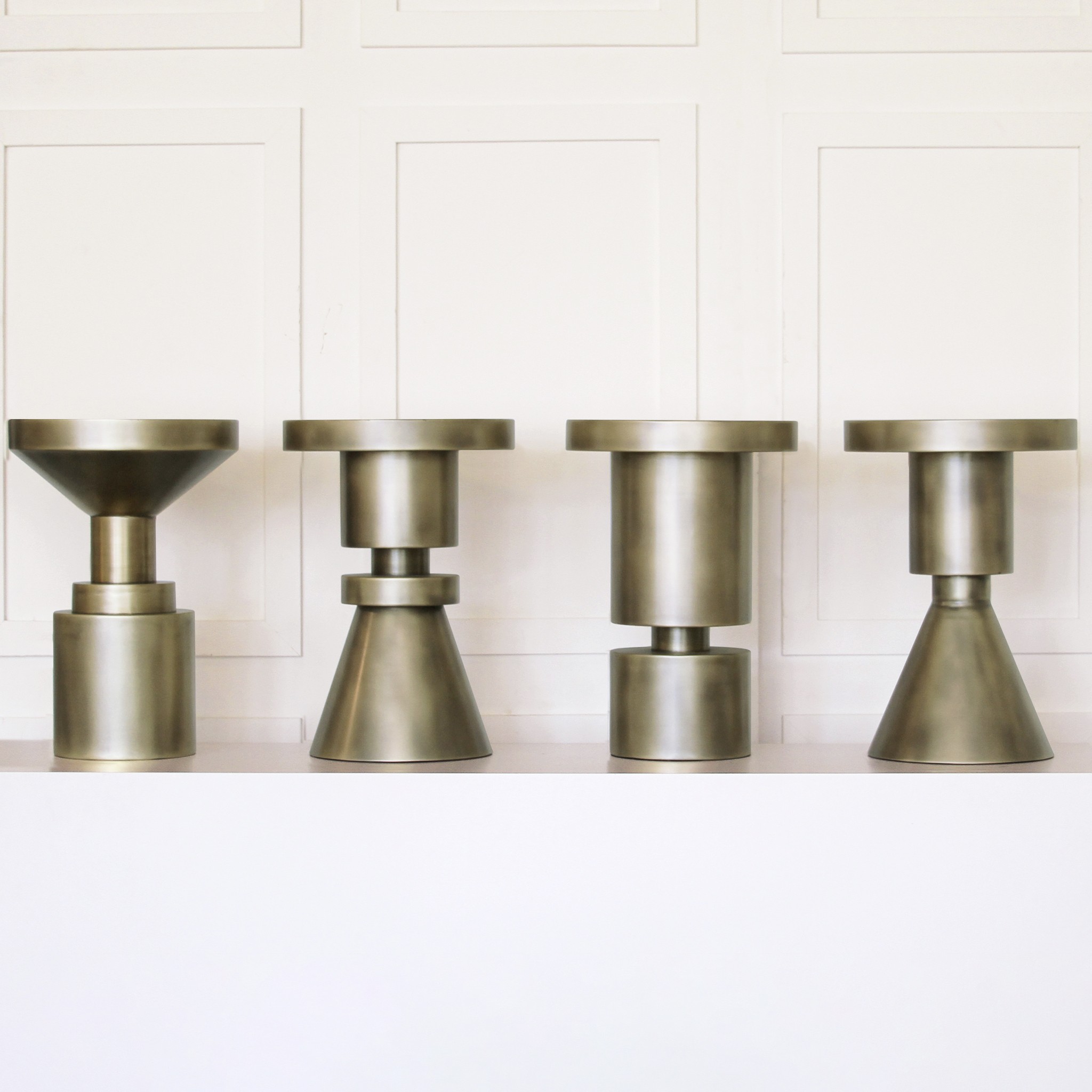 a row of metal vases sitting on top of a shelf