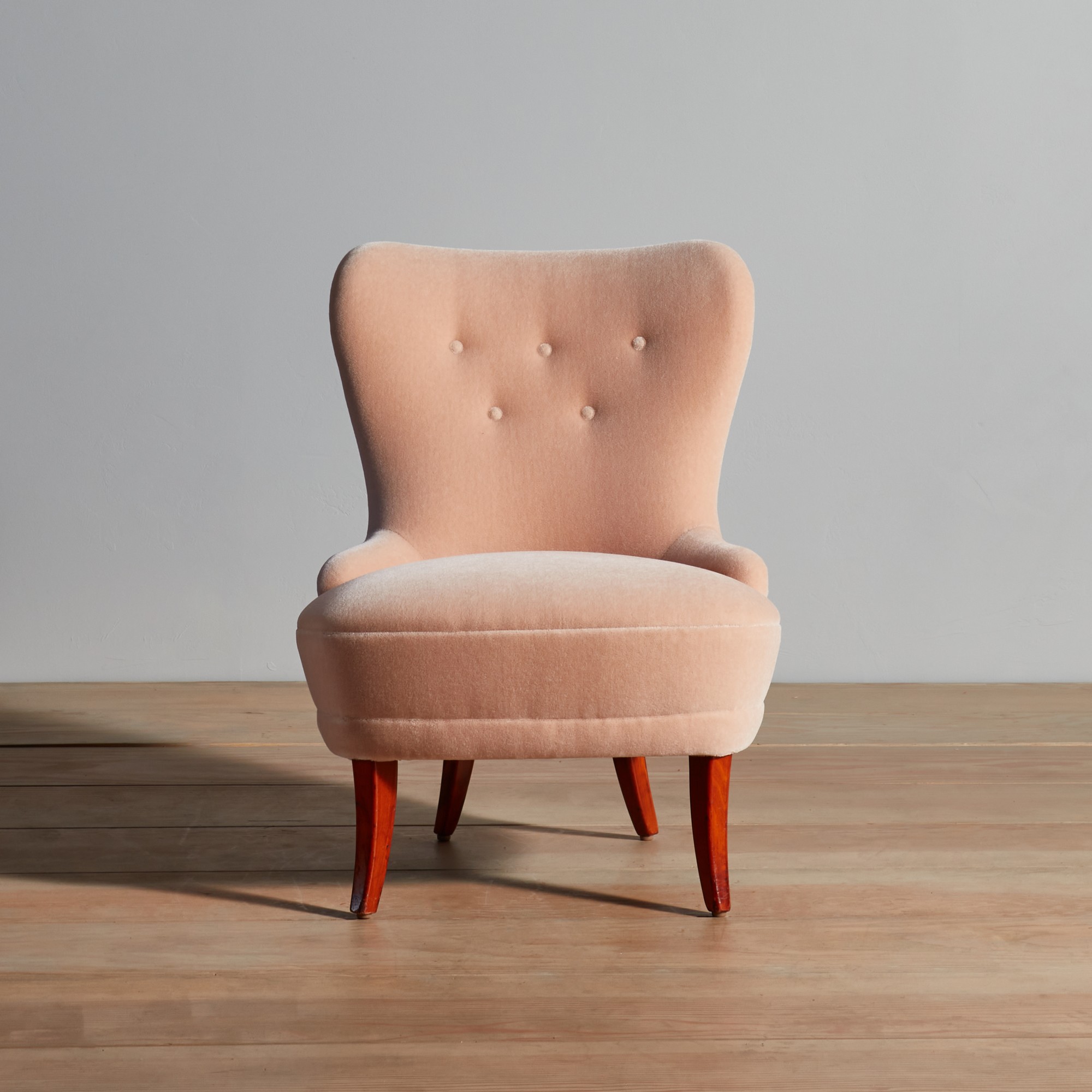 a pink chair sitting on top of a wooden floor