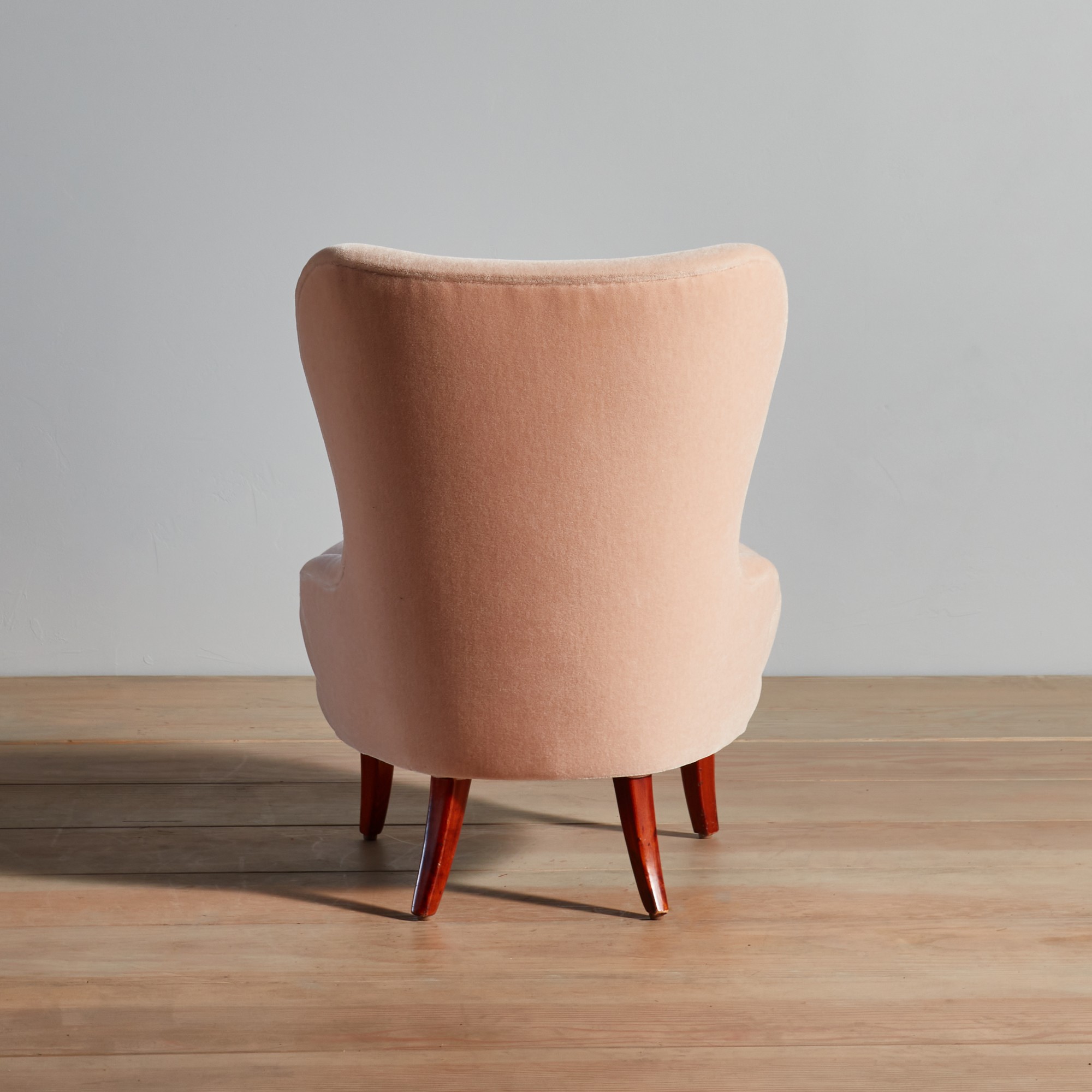a pink chair sitting on top of a wooden floor