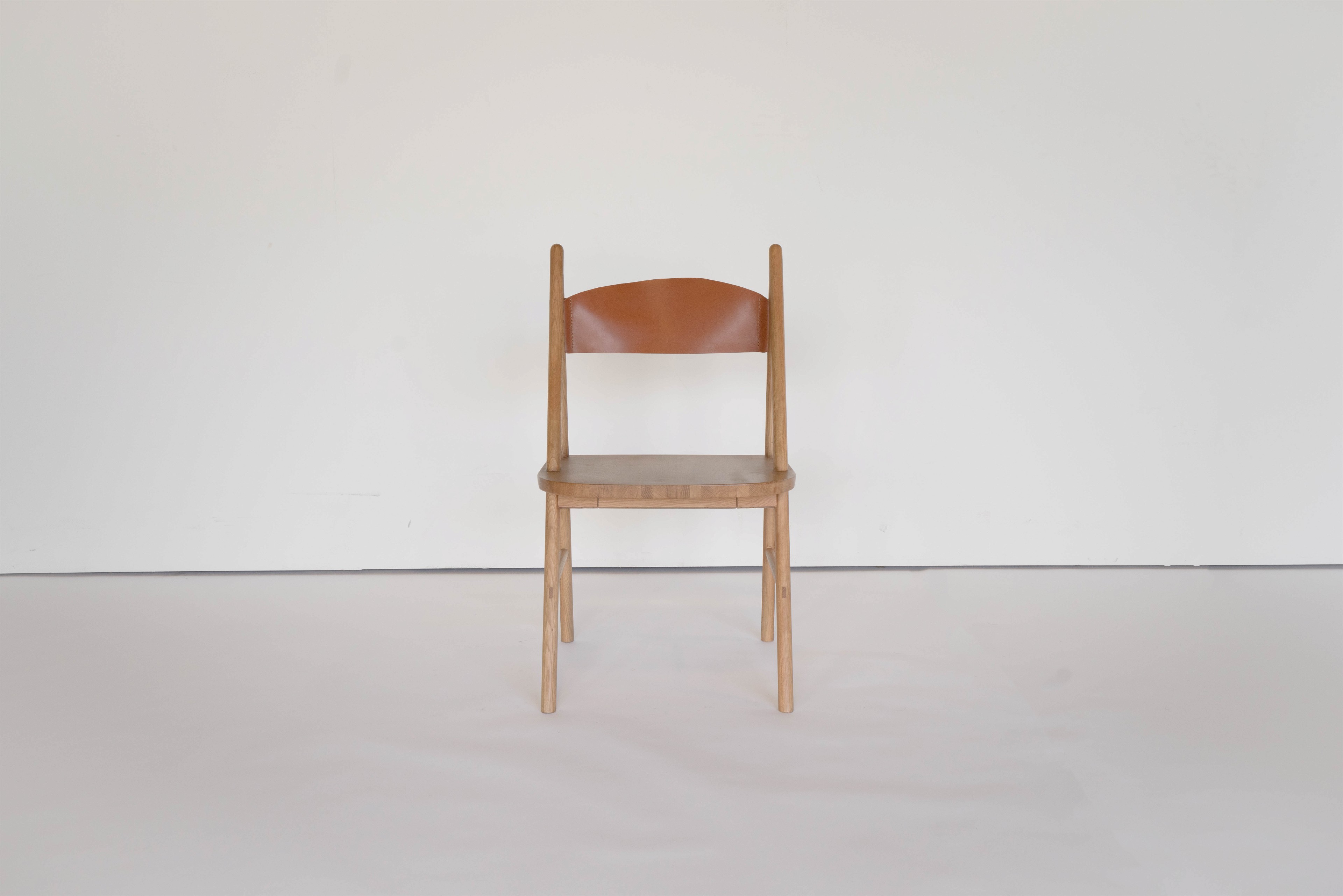 a wooden chair with a brown leather seat