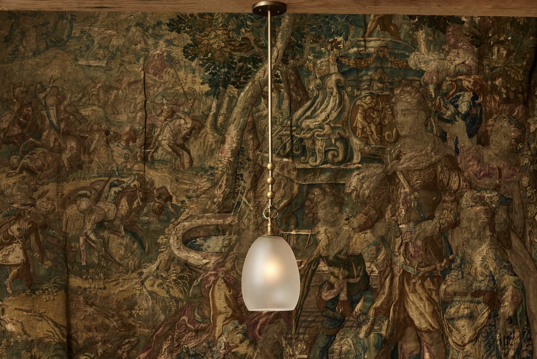 a lamp hanging from a ceiling in front of a painting