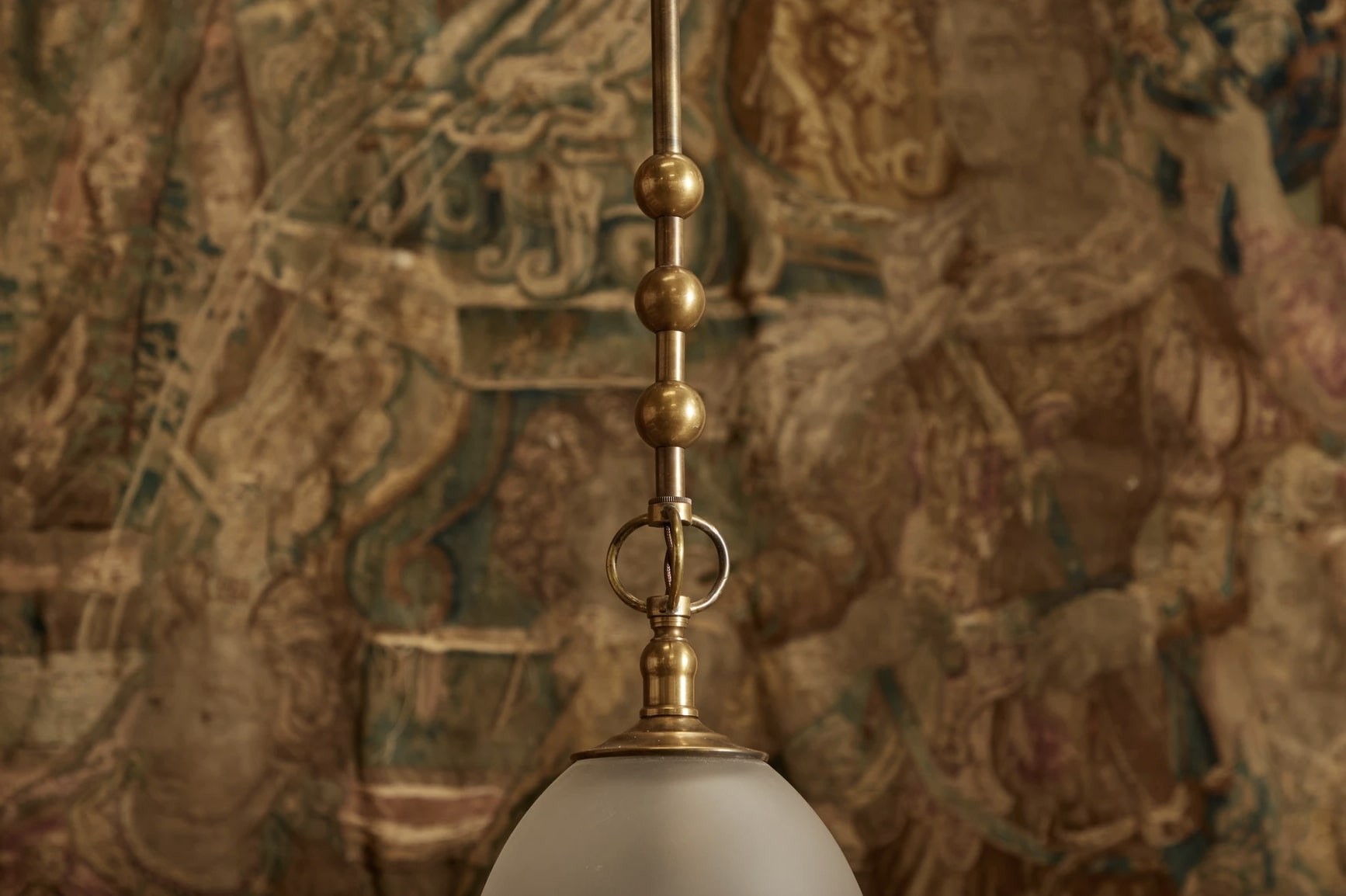 a white and gold light hanging from a ceiling