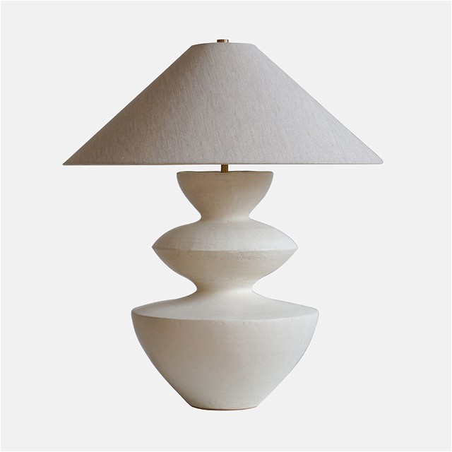 a white table lamp with a white shade on it