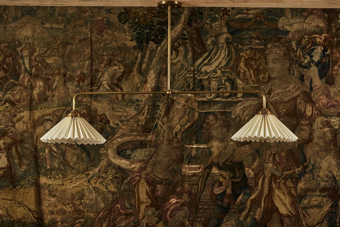 a wall with a painting and two lamps hanging from it