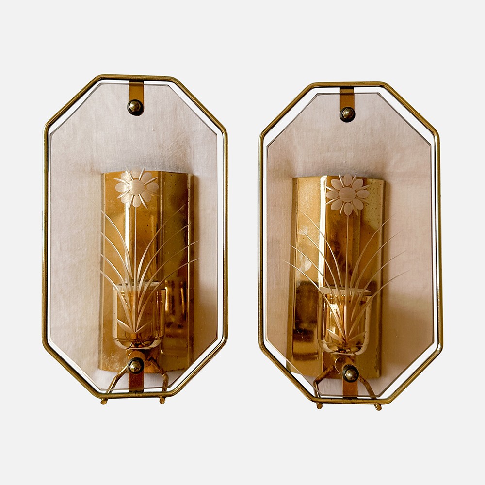 a pair of gold wall sconces with flowers on them