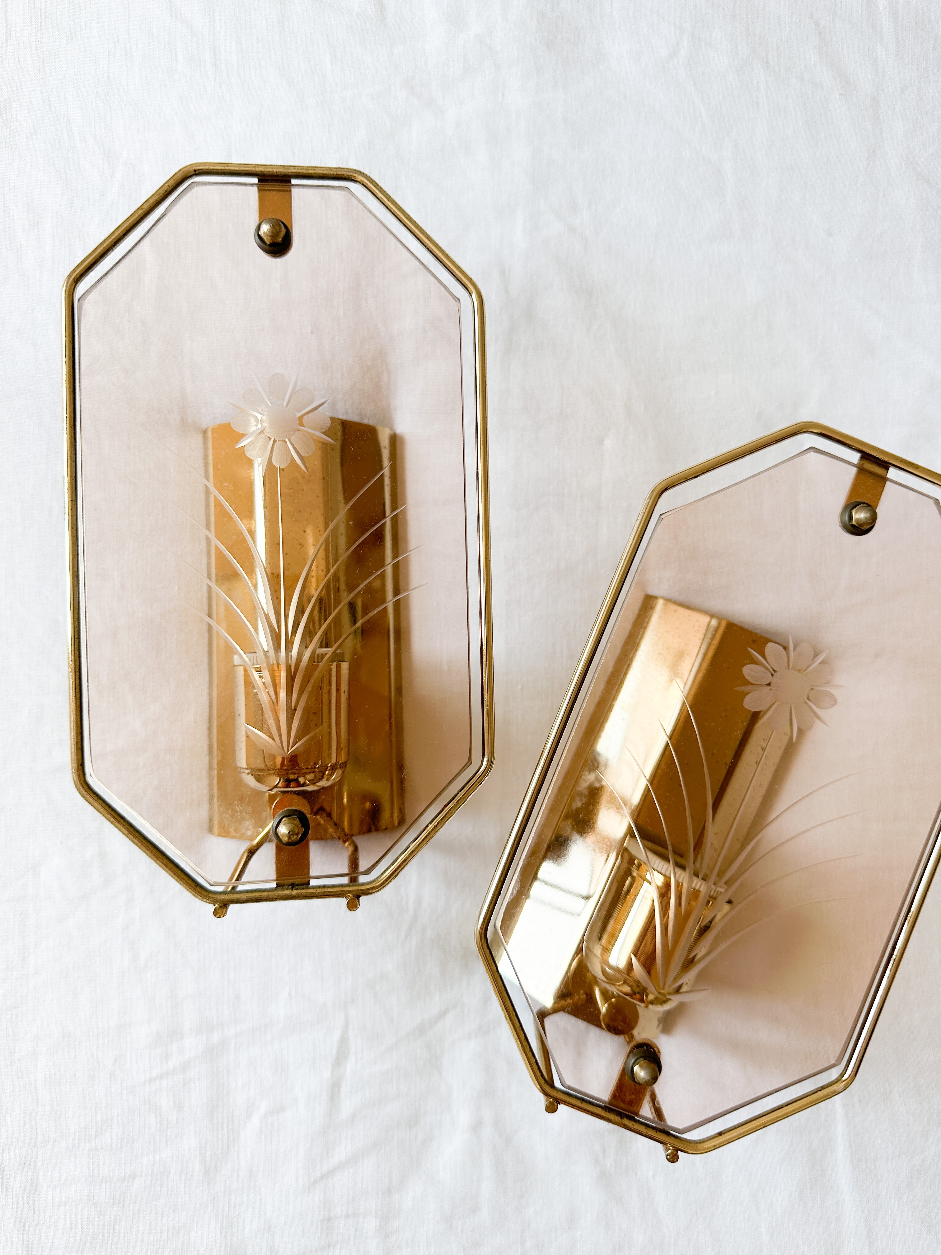 a pair of wall sconces with gold decorations