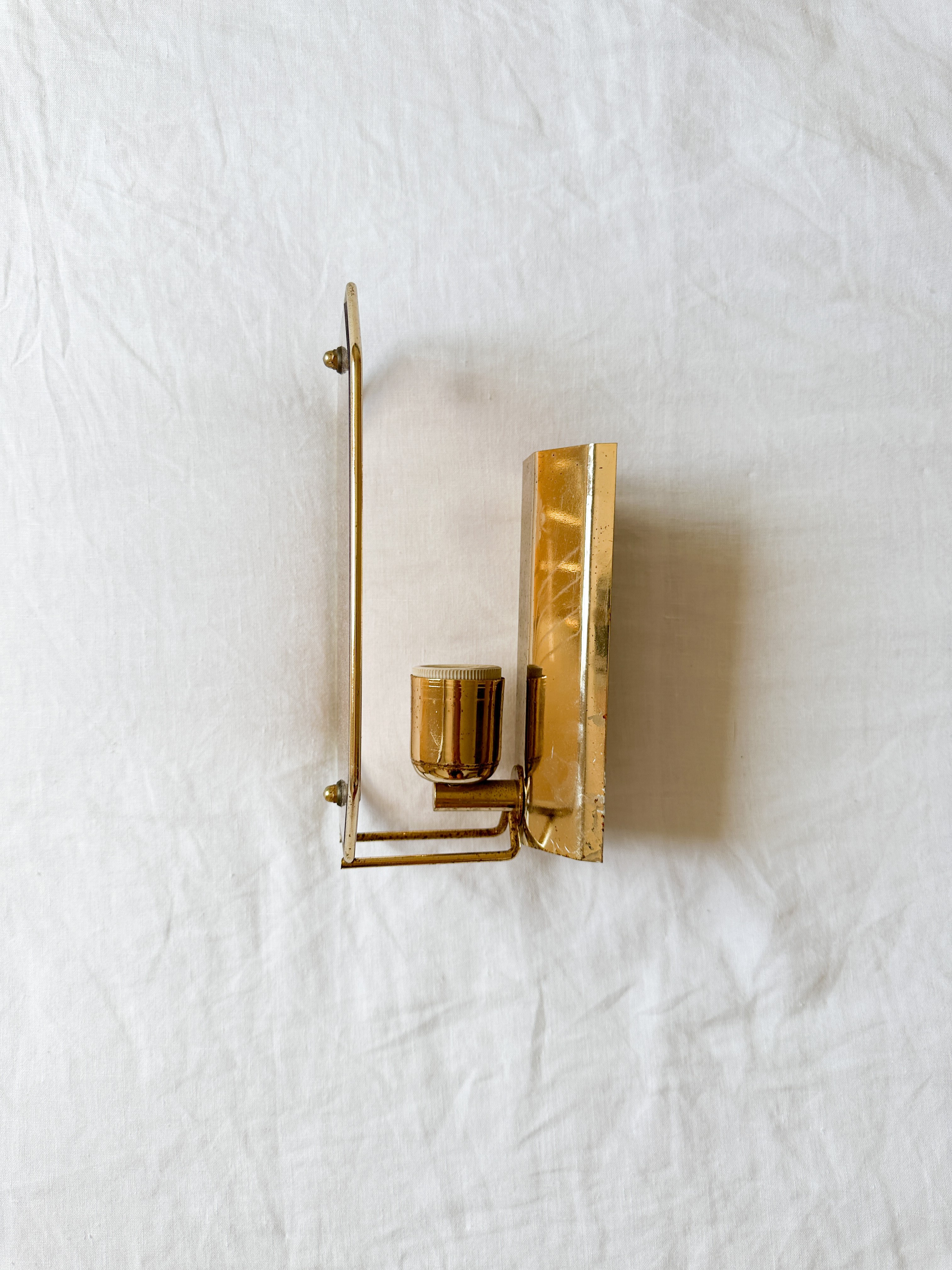 a gold candle holder on a white sheet