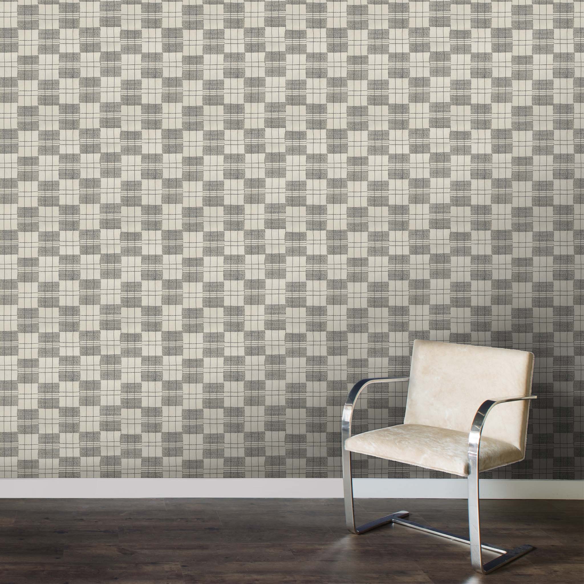 a chair sitting in front of a wall with a checkered pattern on it
