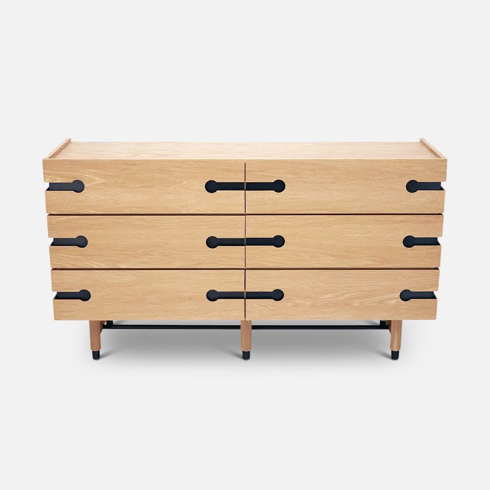 a wooden chest of drawers with black handles