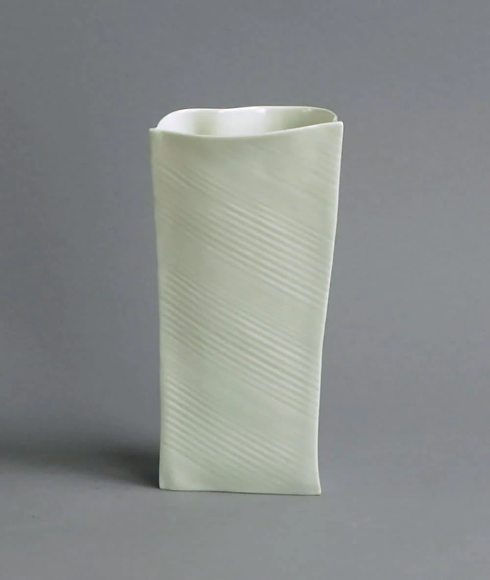 a white vase sitting on top of a table