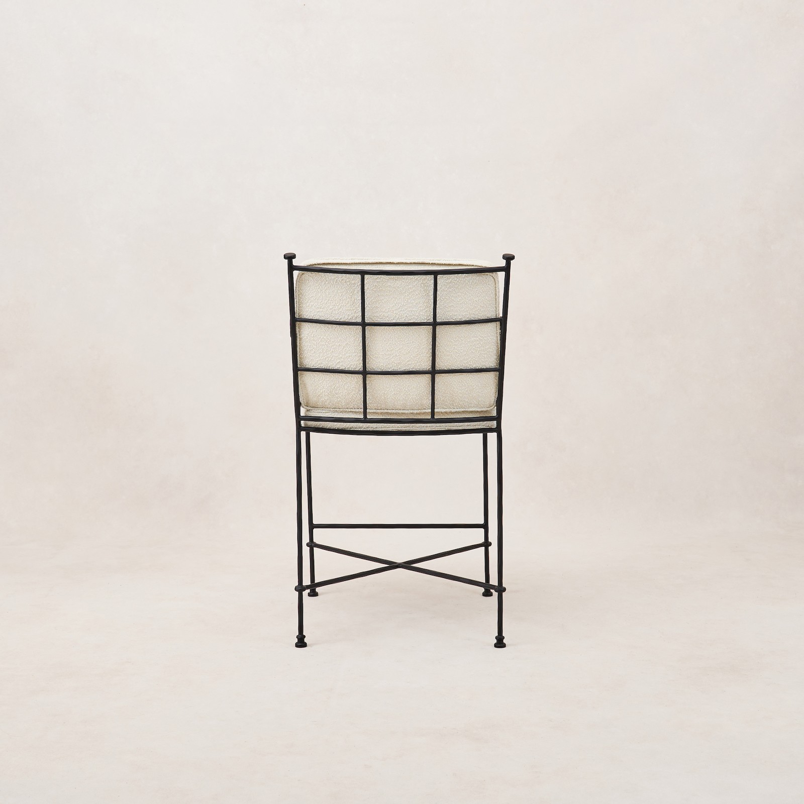 a black iron chair with a white fabric seat