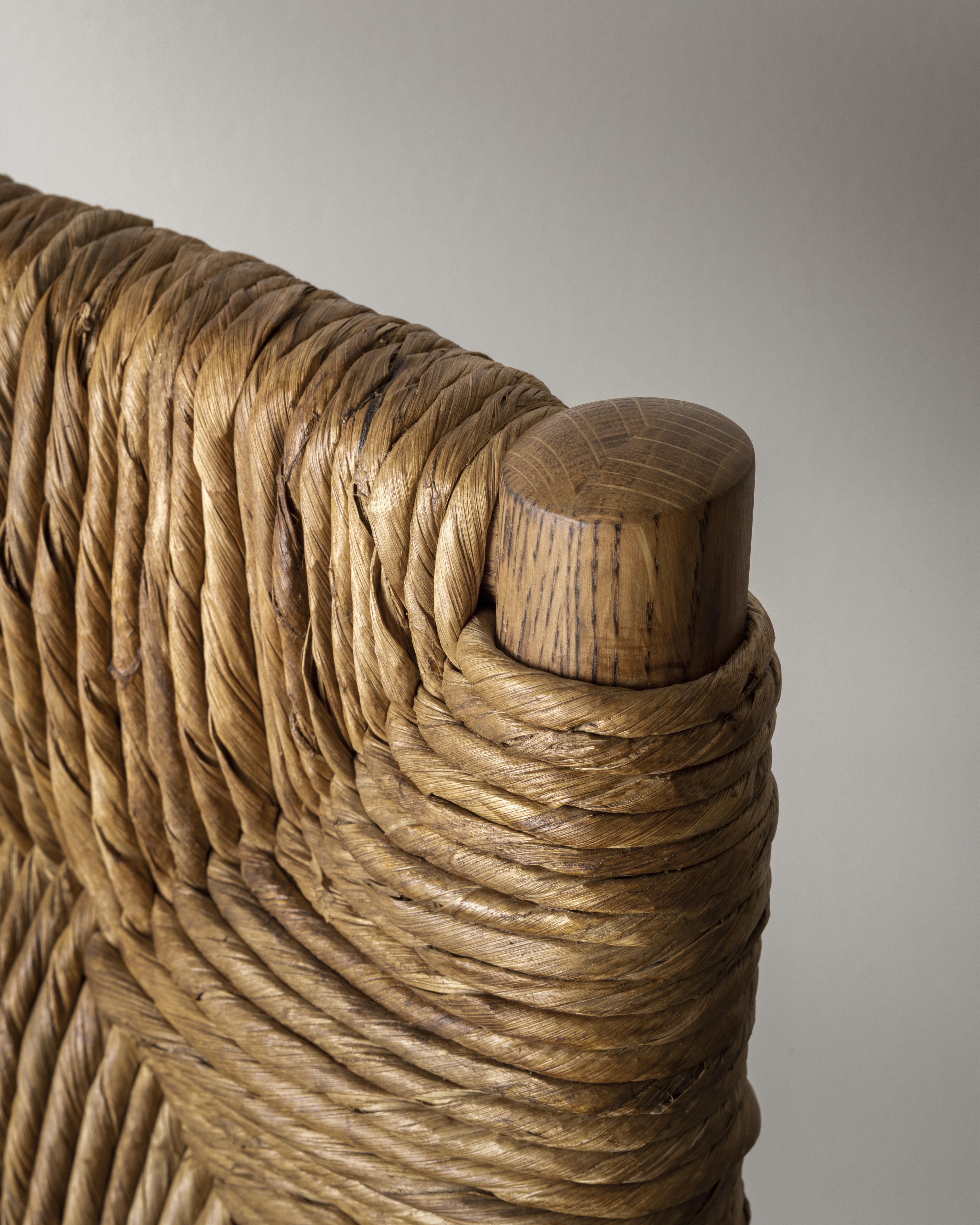 a close up of a wooden bench made of rope