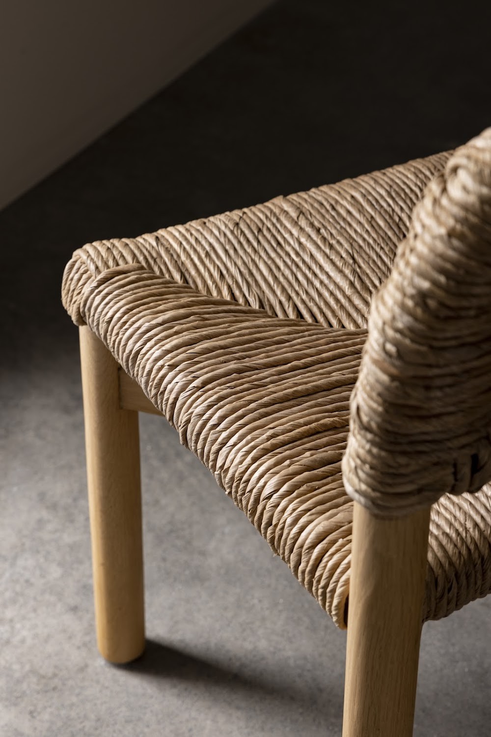 a close up of a wooden chair with a woven seat