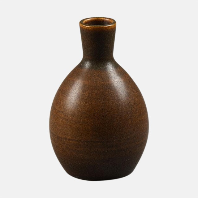 a brown vase sitting on top of a white surface