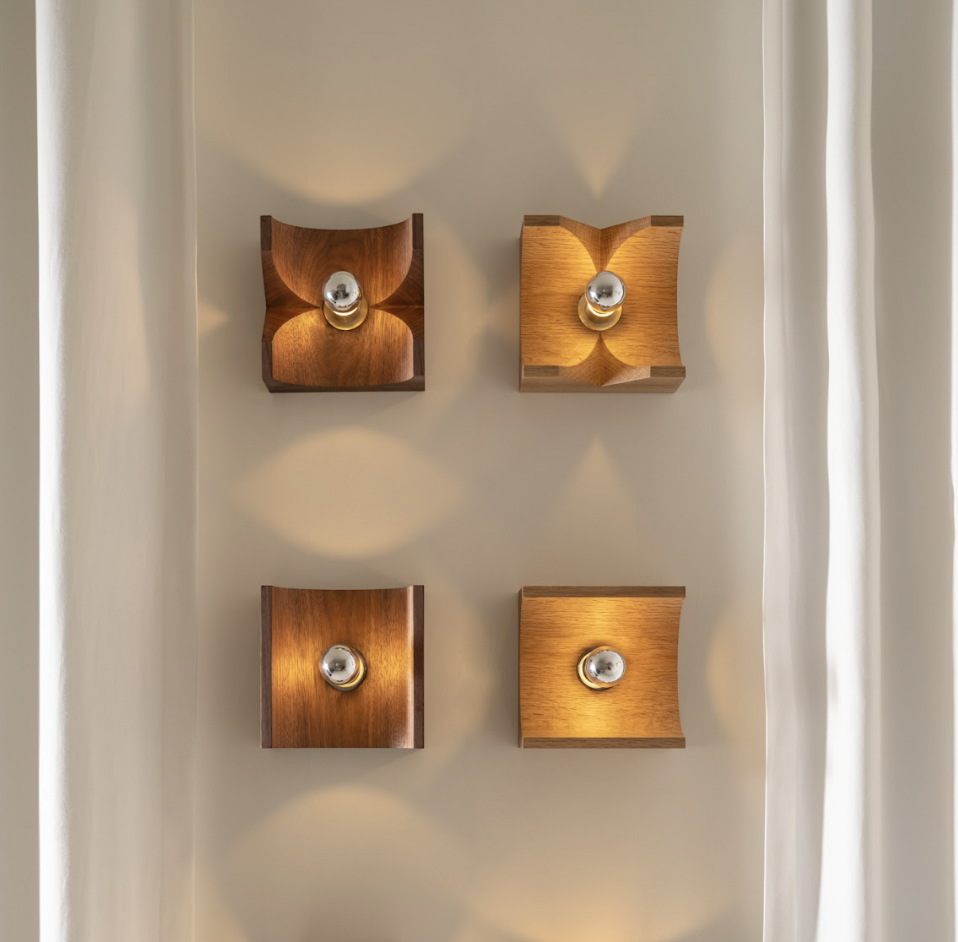 a wall mounted light with three square lights on it