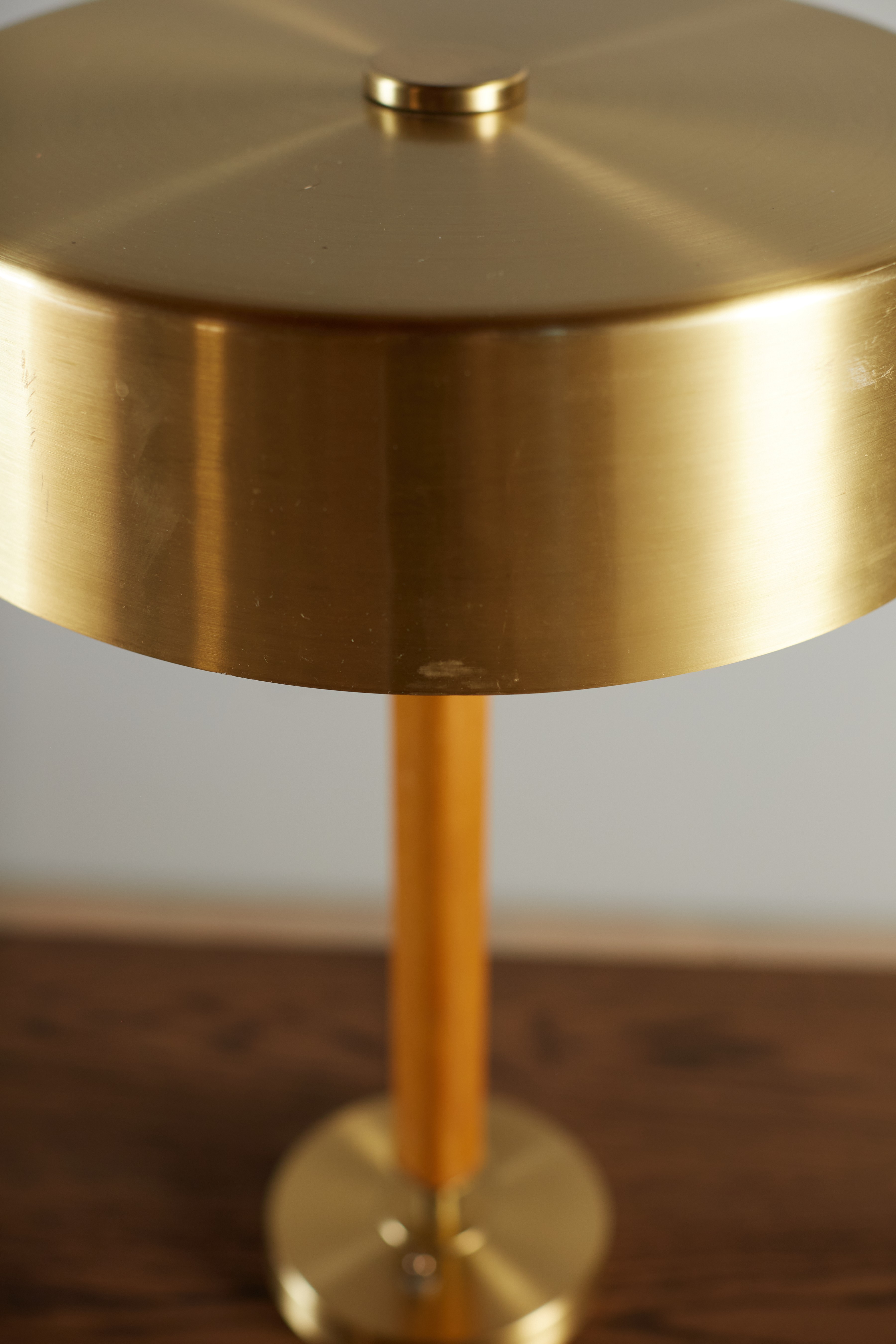 a gold plate on a wooden table with a wooden base