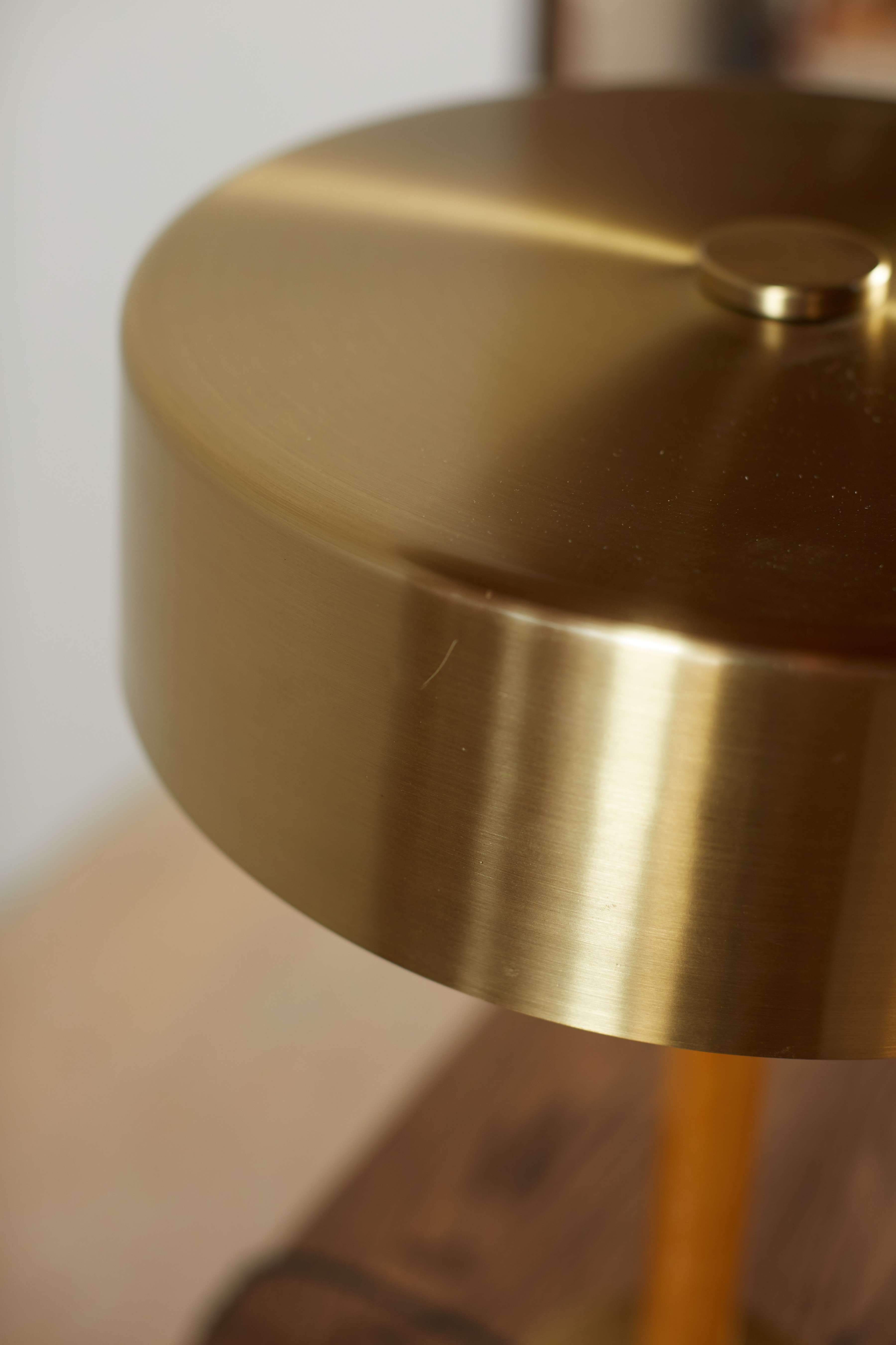 a close up of a gold colored table lamp