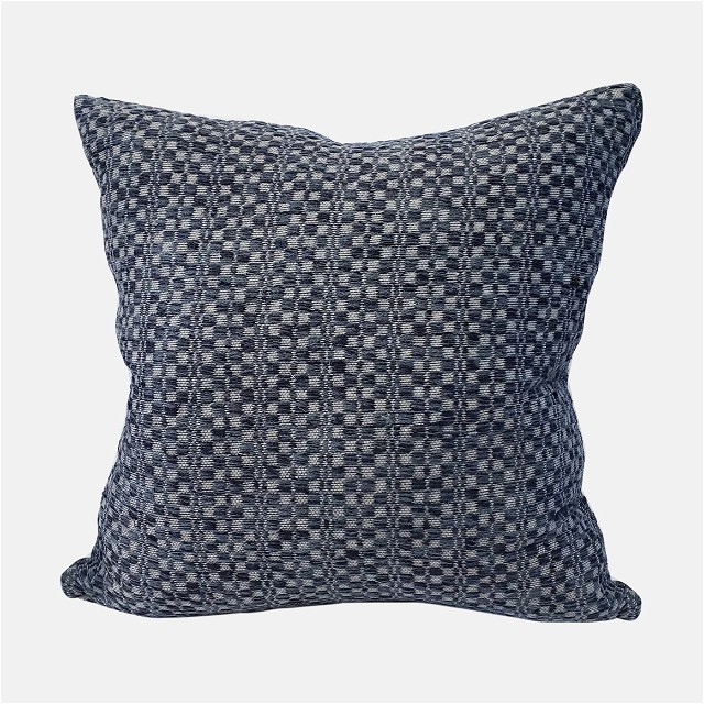 a black and white checkered pillow on a white background