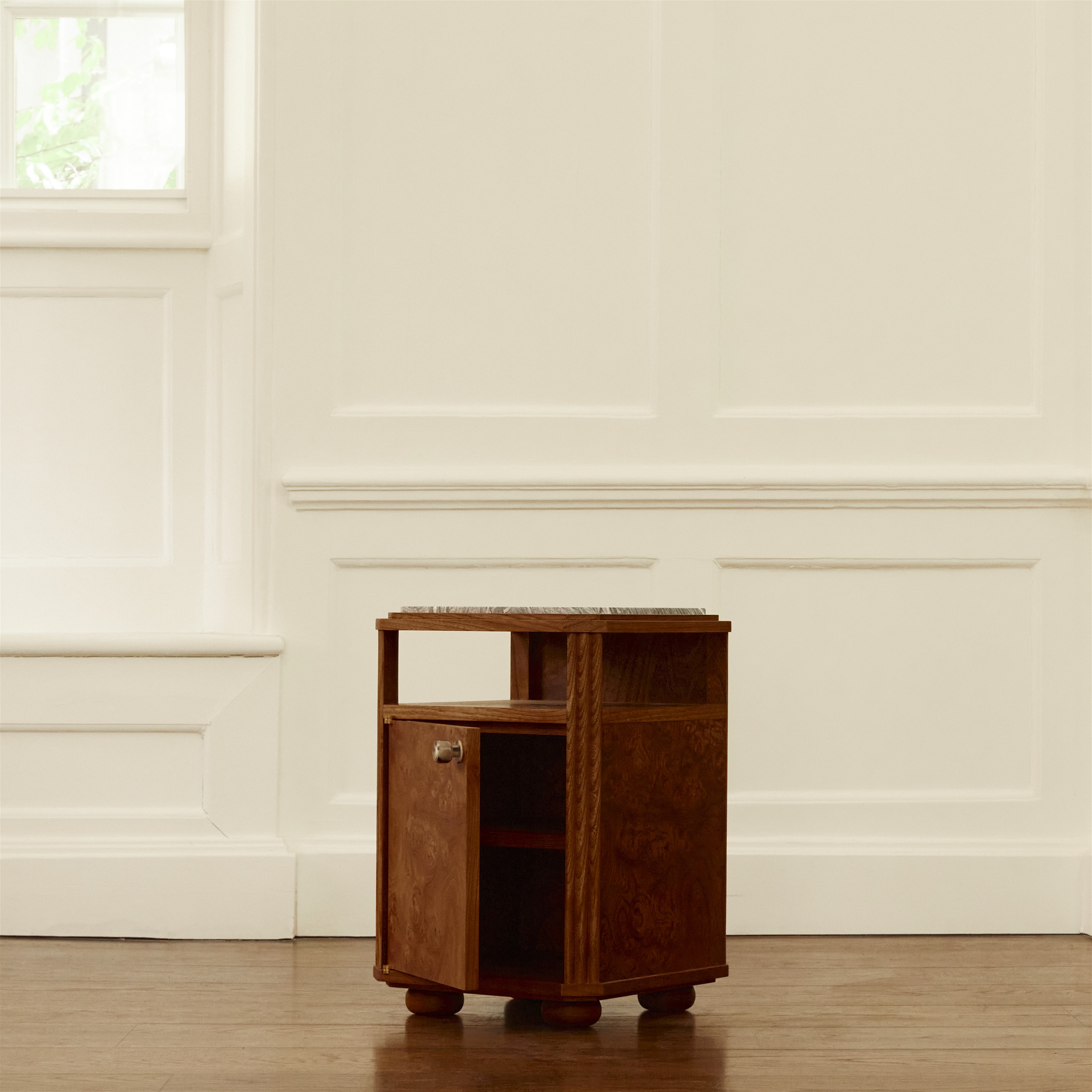 a small wooden cabinet sitting on top of a hard wood floor