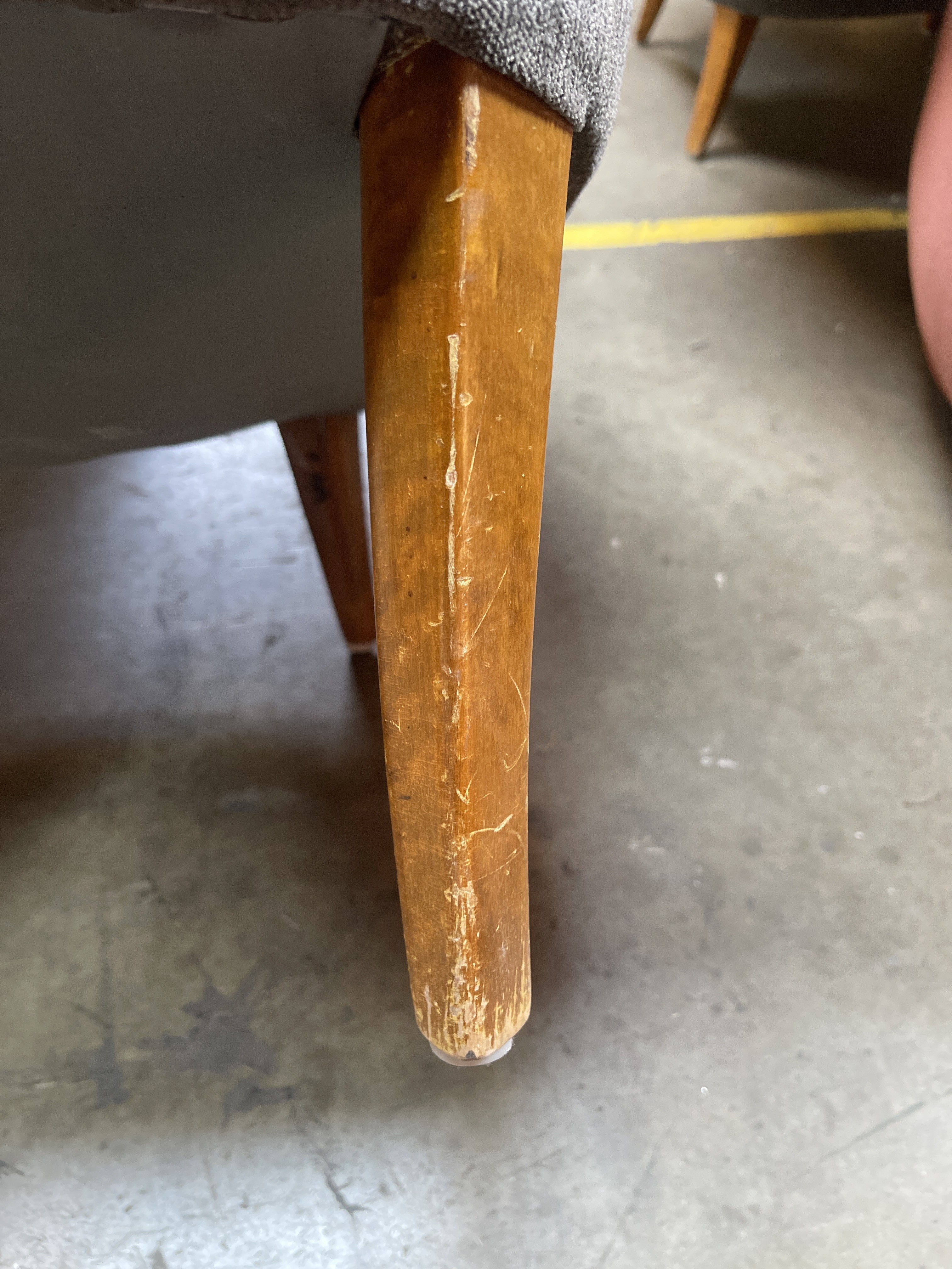 a close up of a chair with a wooden leg