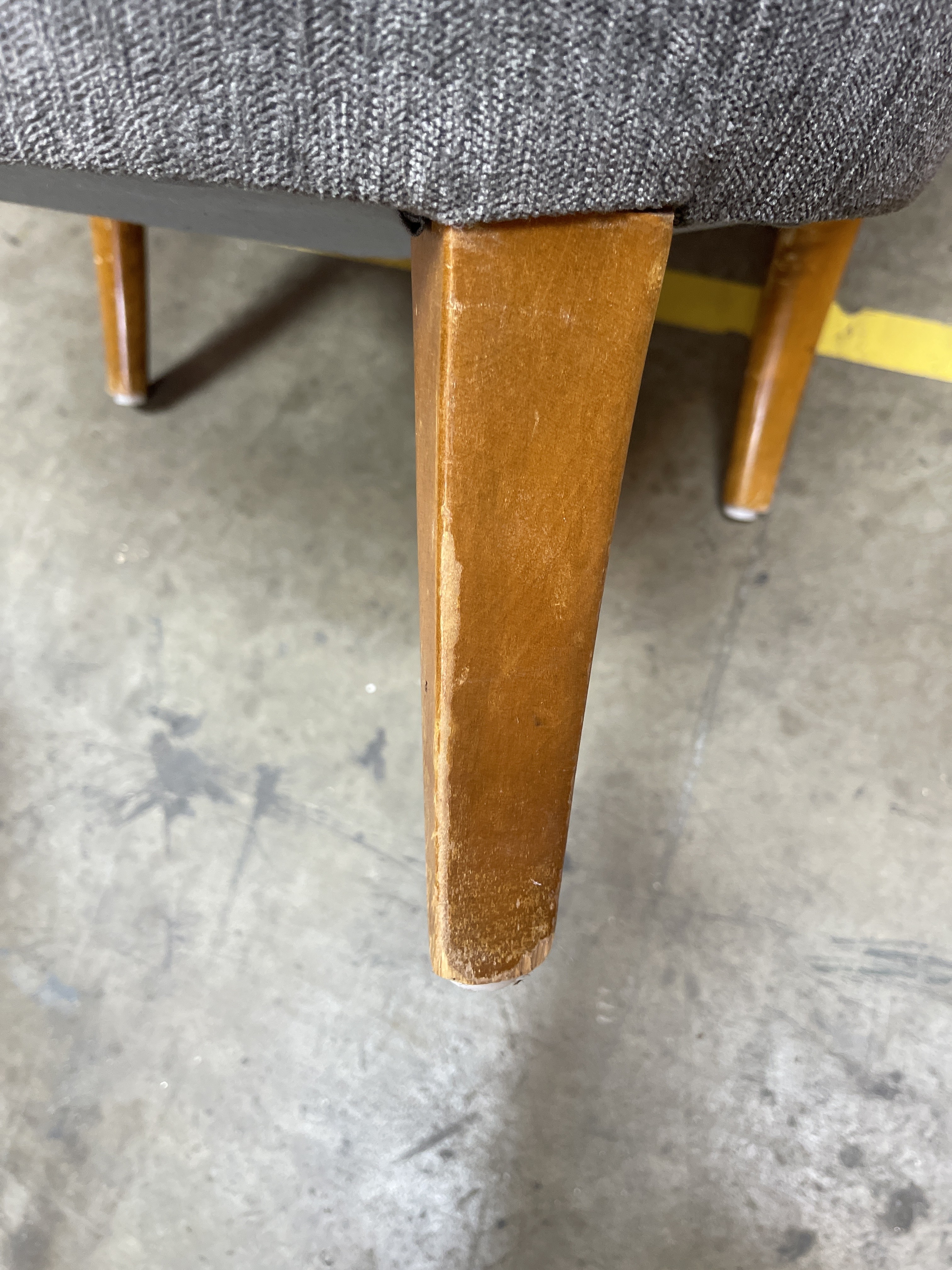a close up of a wooden chair with a gray seat
