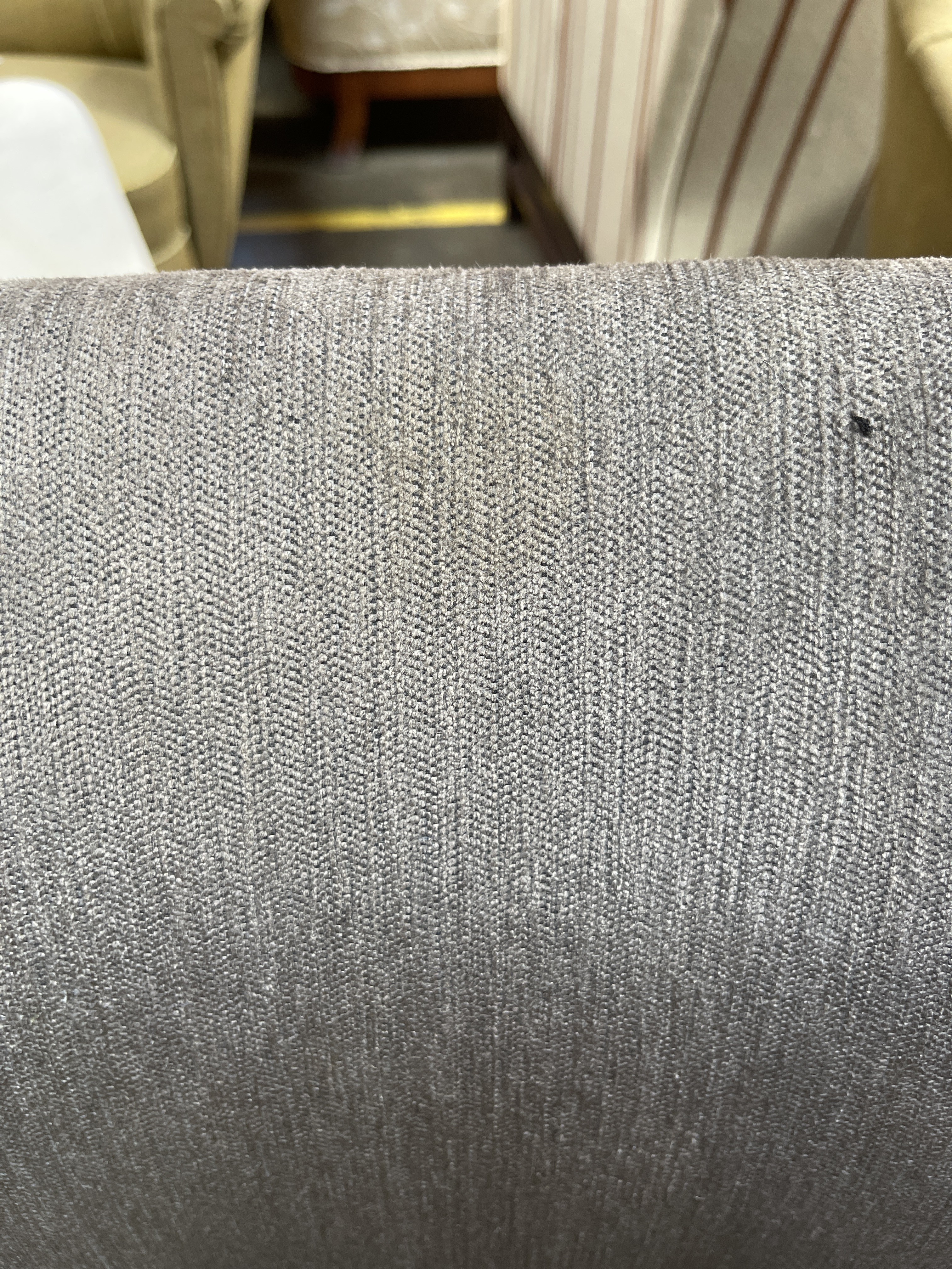 a close up of a chair with a gray fabric