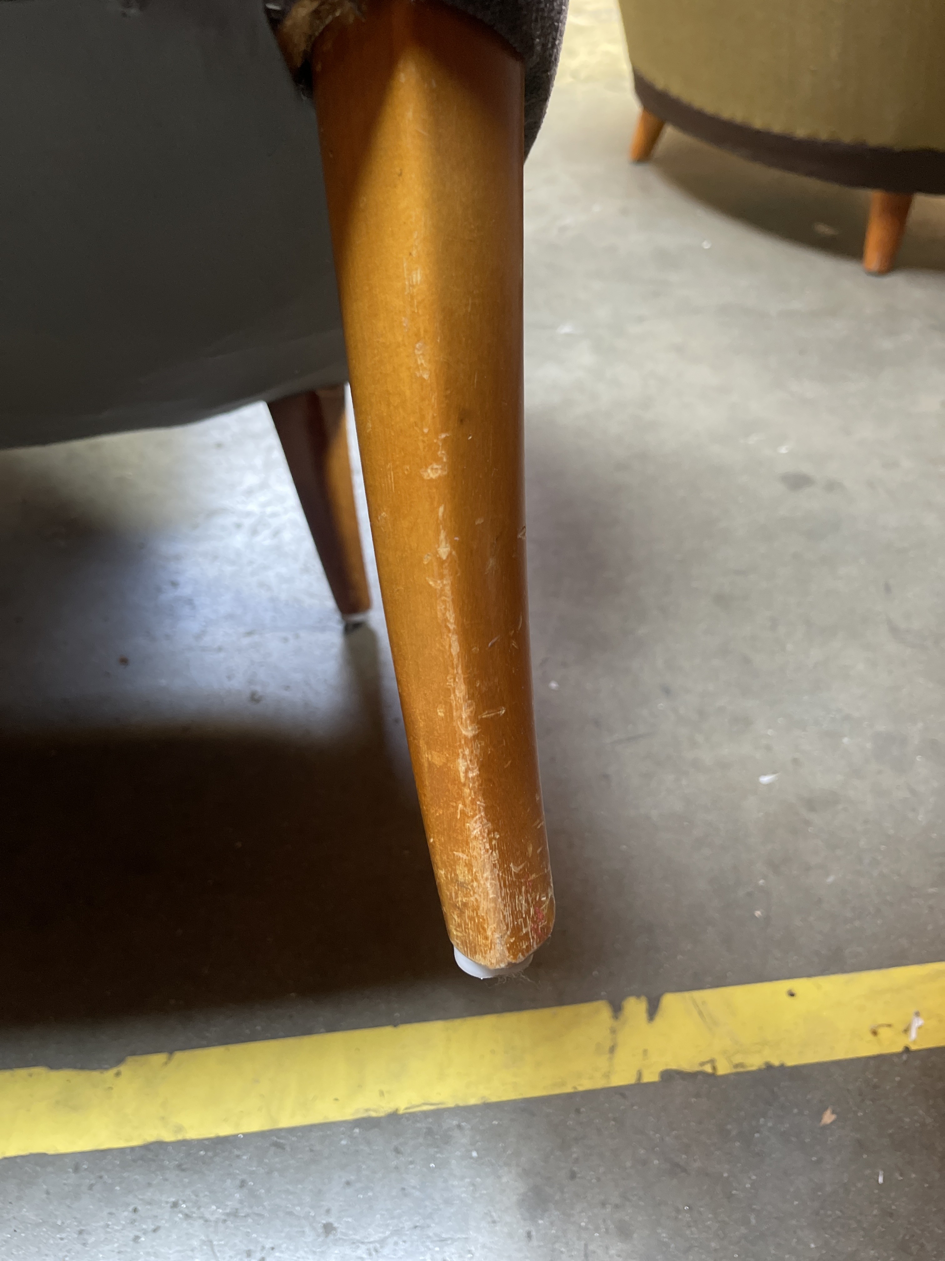 a close up of a chair with a wooden leg