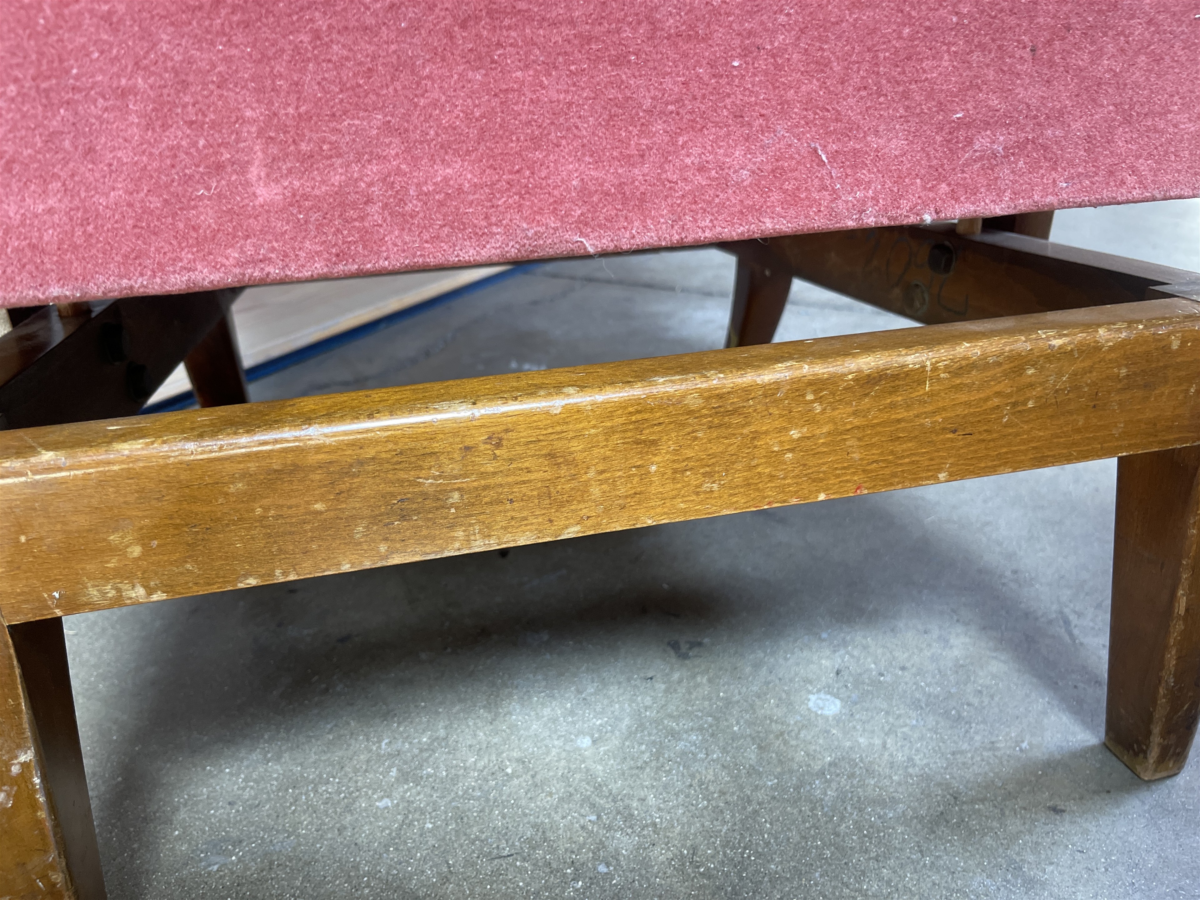 a wooden bench with a red upholstered seat