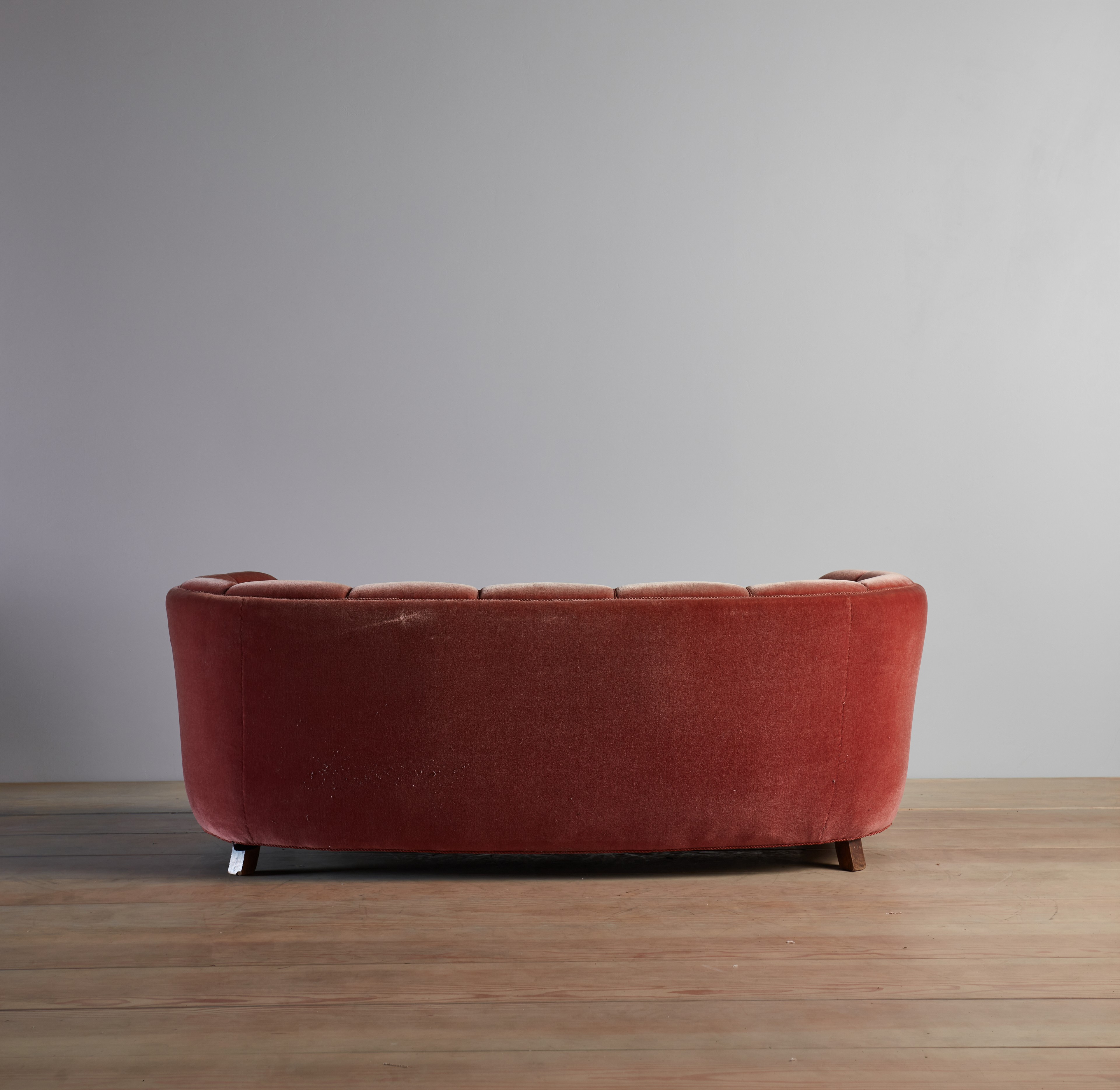 a red couch sitting on top of a wooden floor