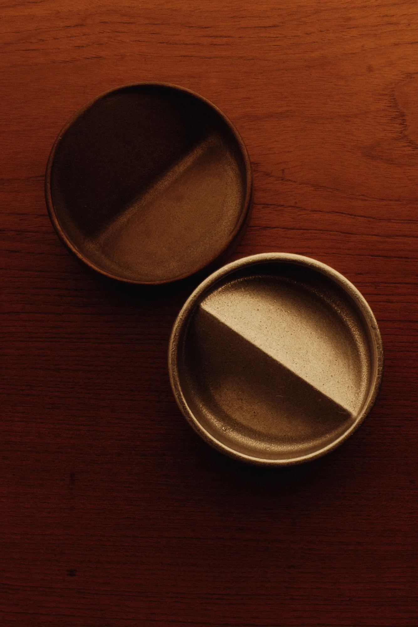 two empty tins sitting on top of a wooden table