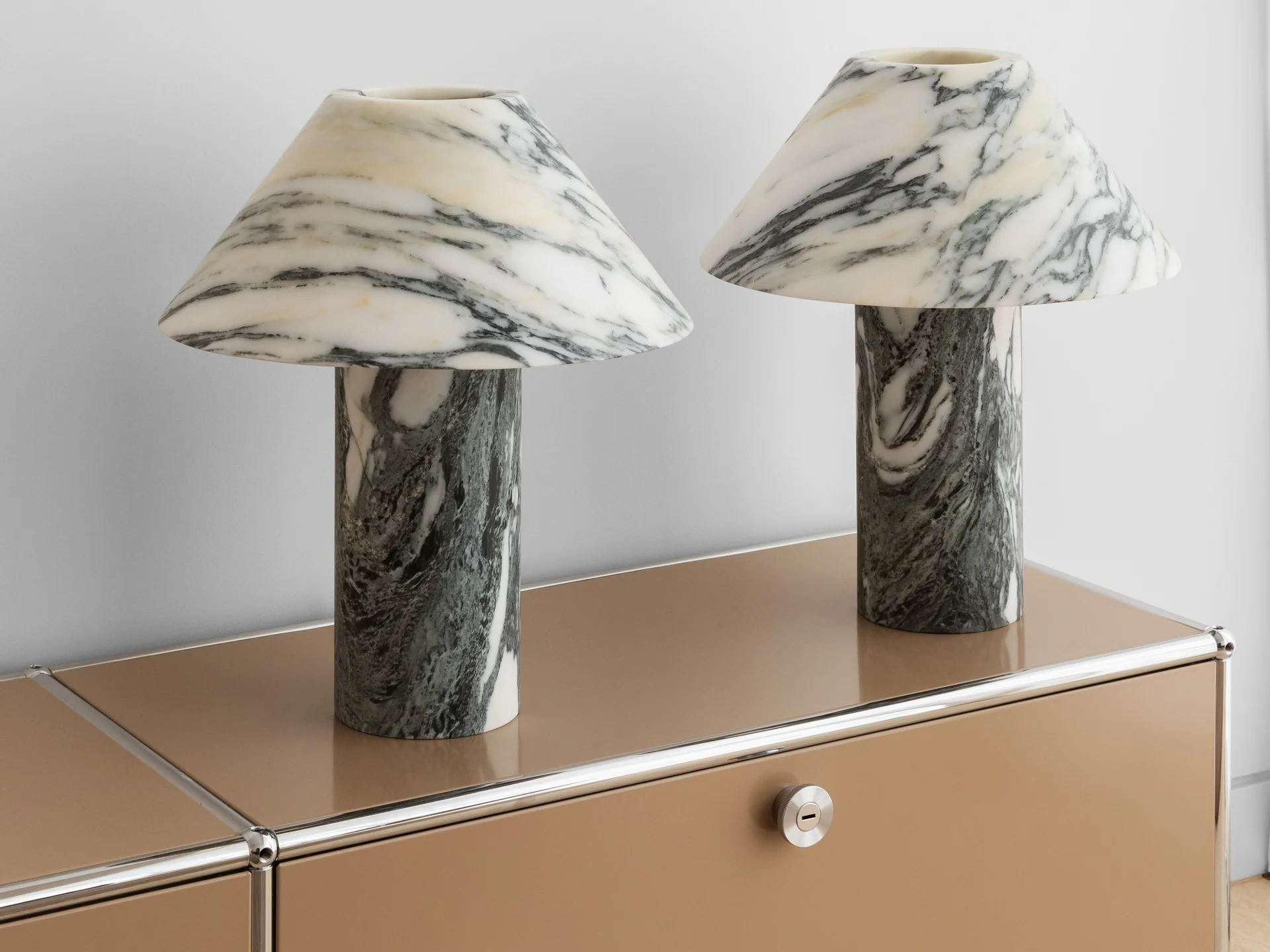 two marbled lamps are sitting on a dresser