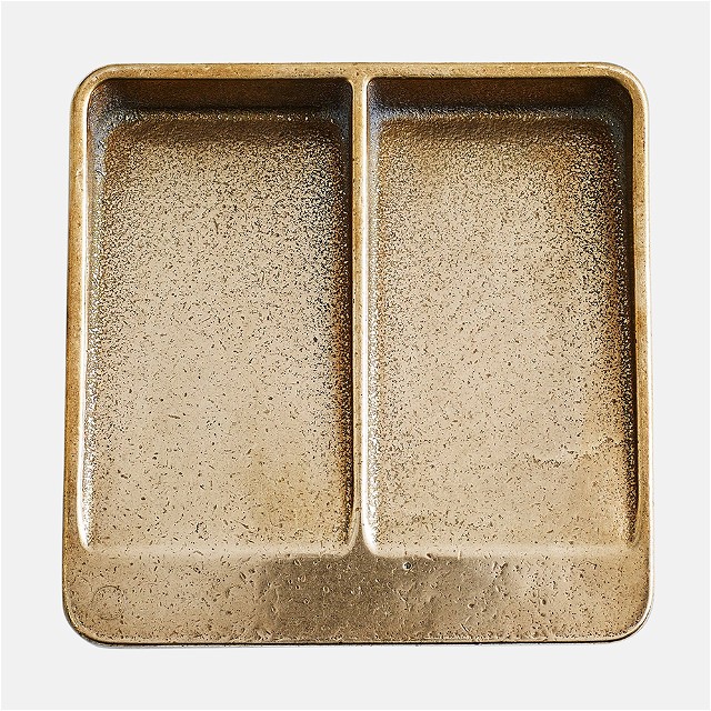 a metal tray with two compartments for food