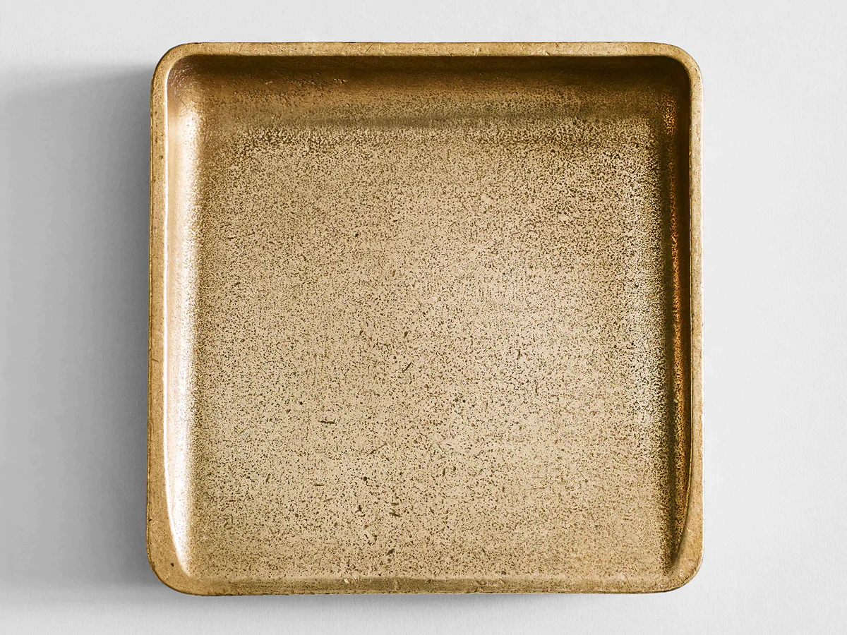 a square gold tray with a white background