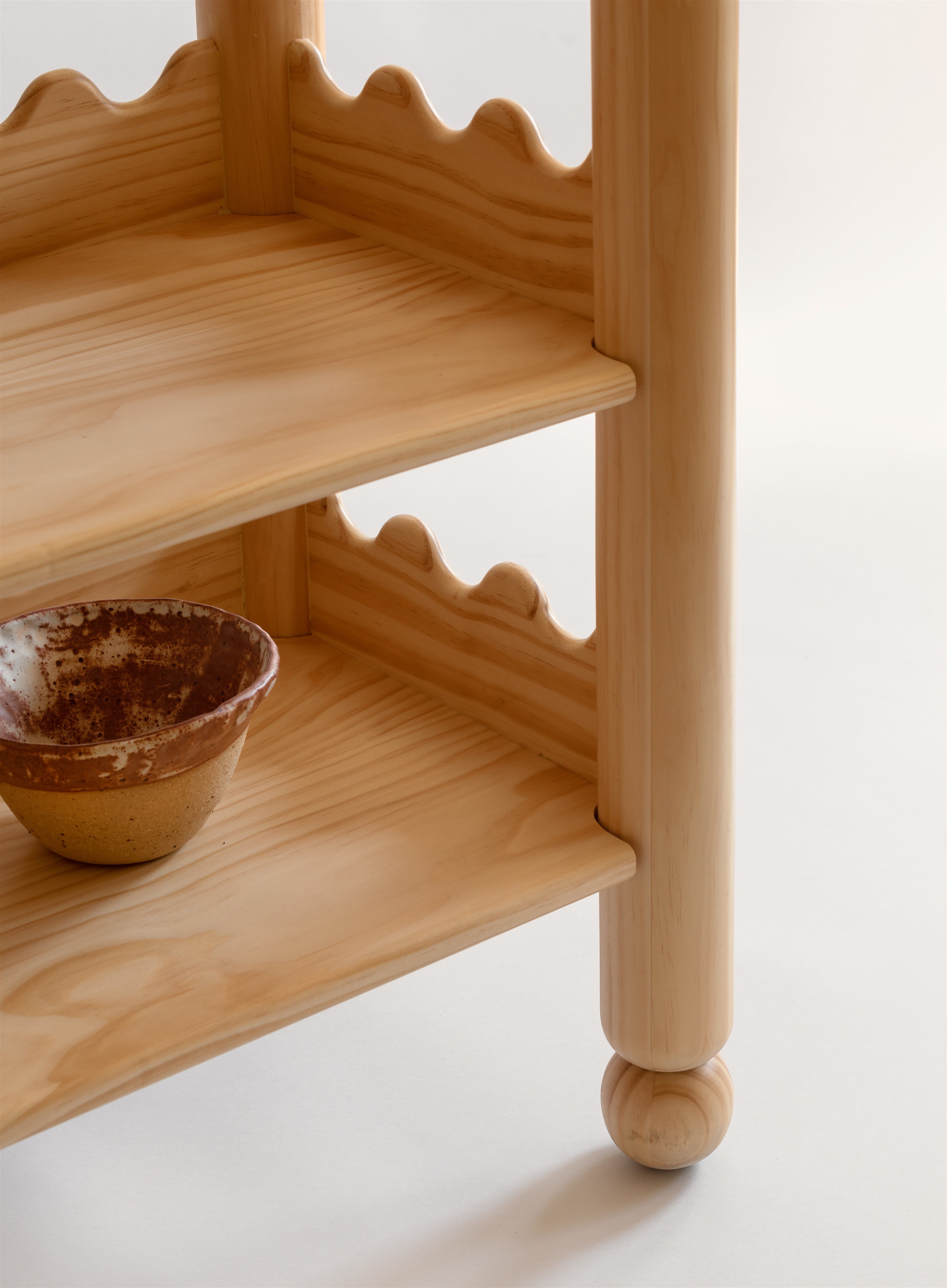 a wooden shelf with a bowl on top of it