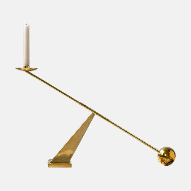 a brass candle holder with a single candle