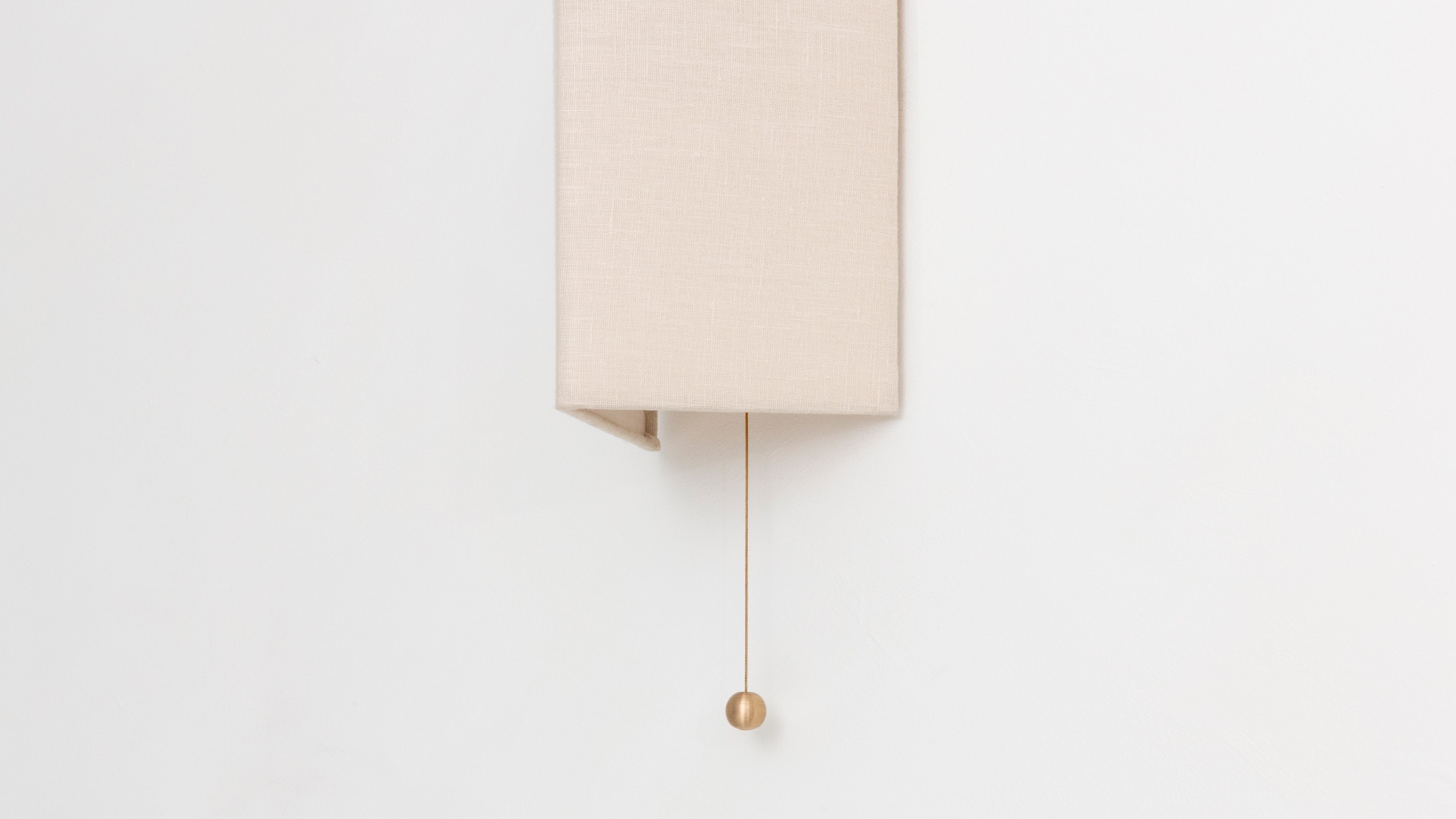 a white wall mounted clock with a beige cover