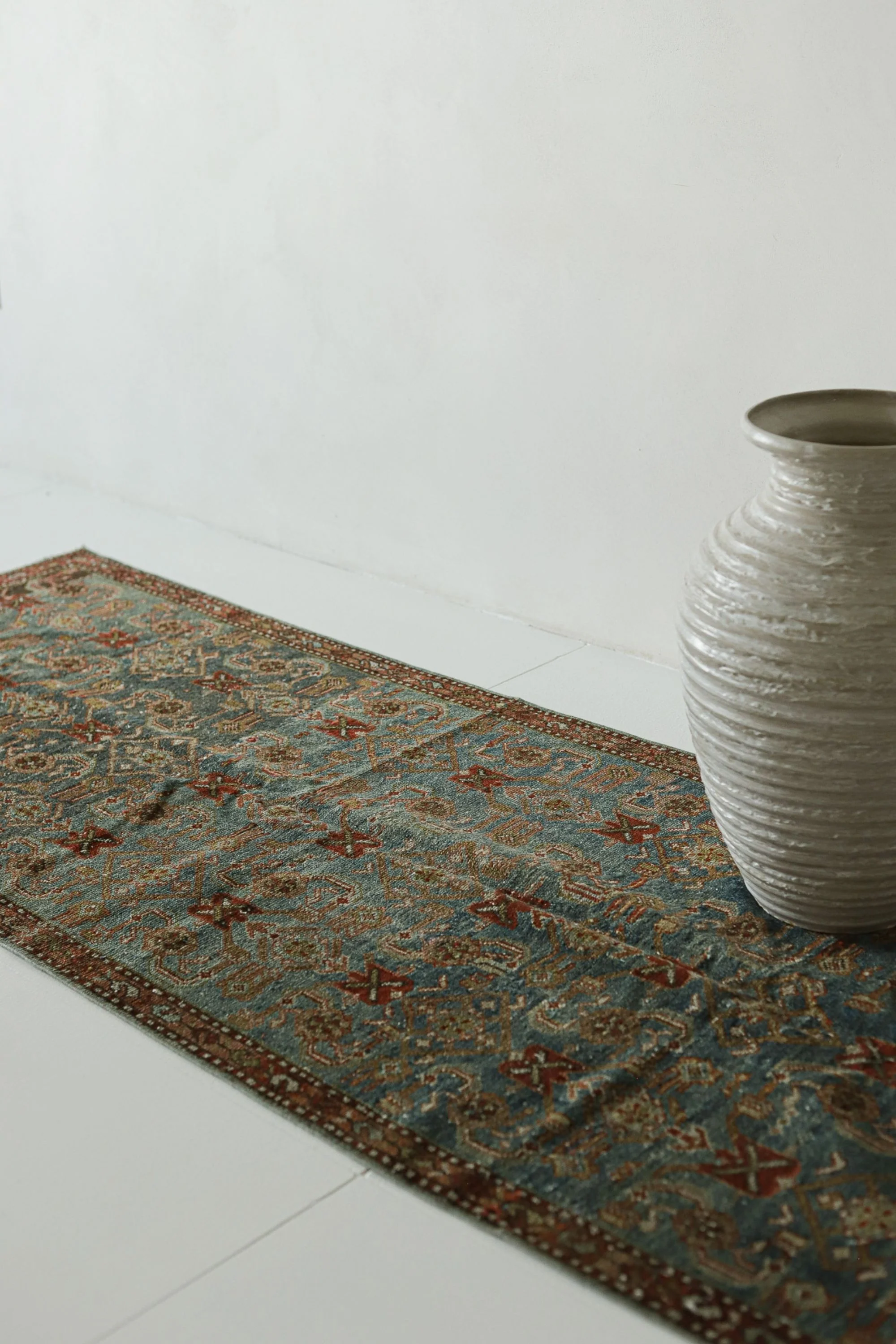 a white vase sitting on top of a rug