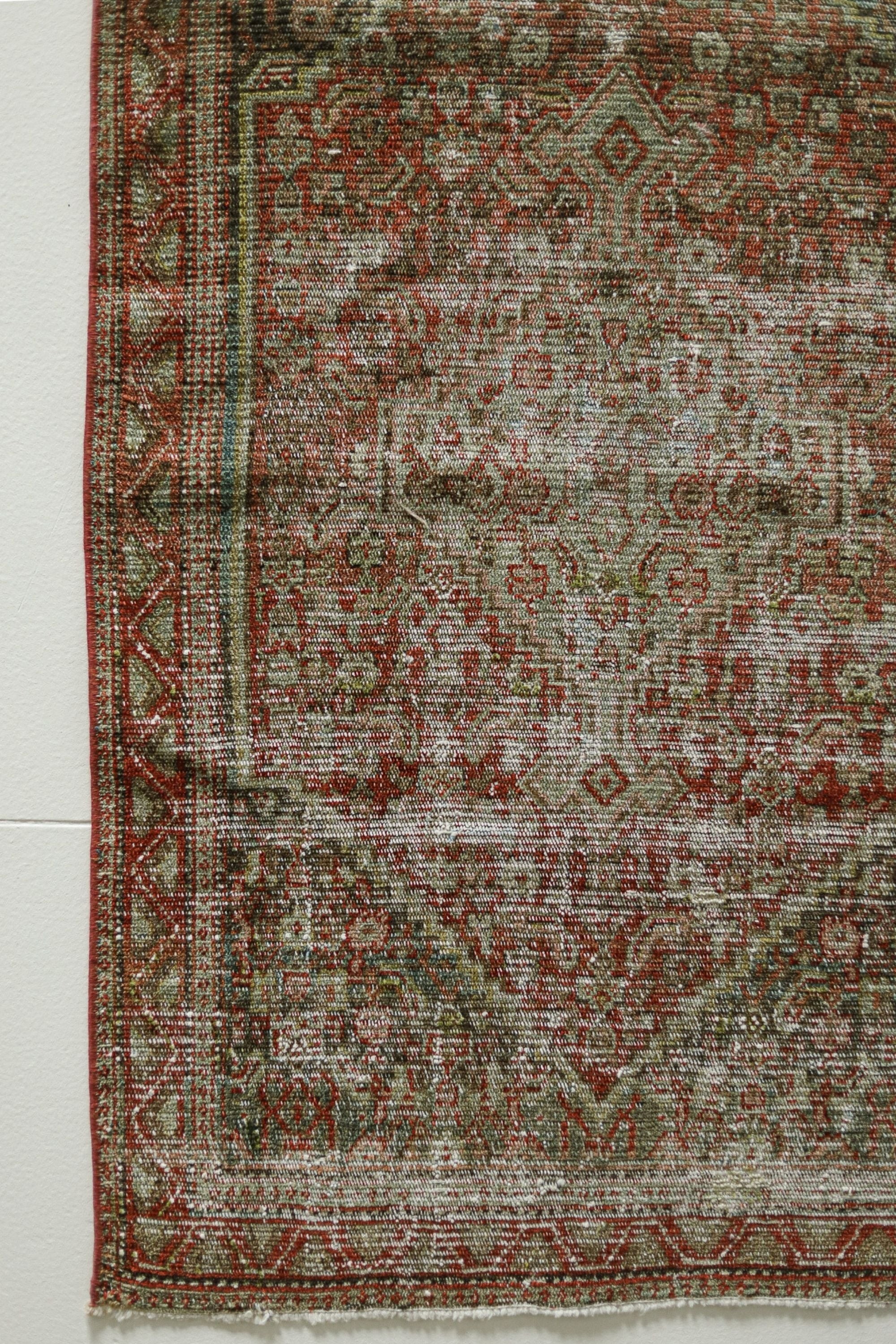 a red and green rug on a white wall