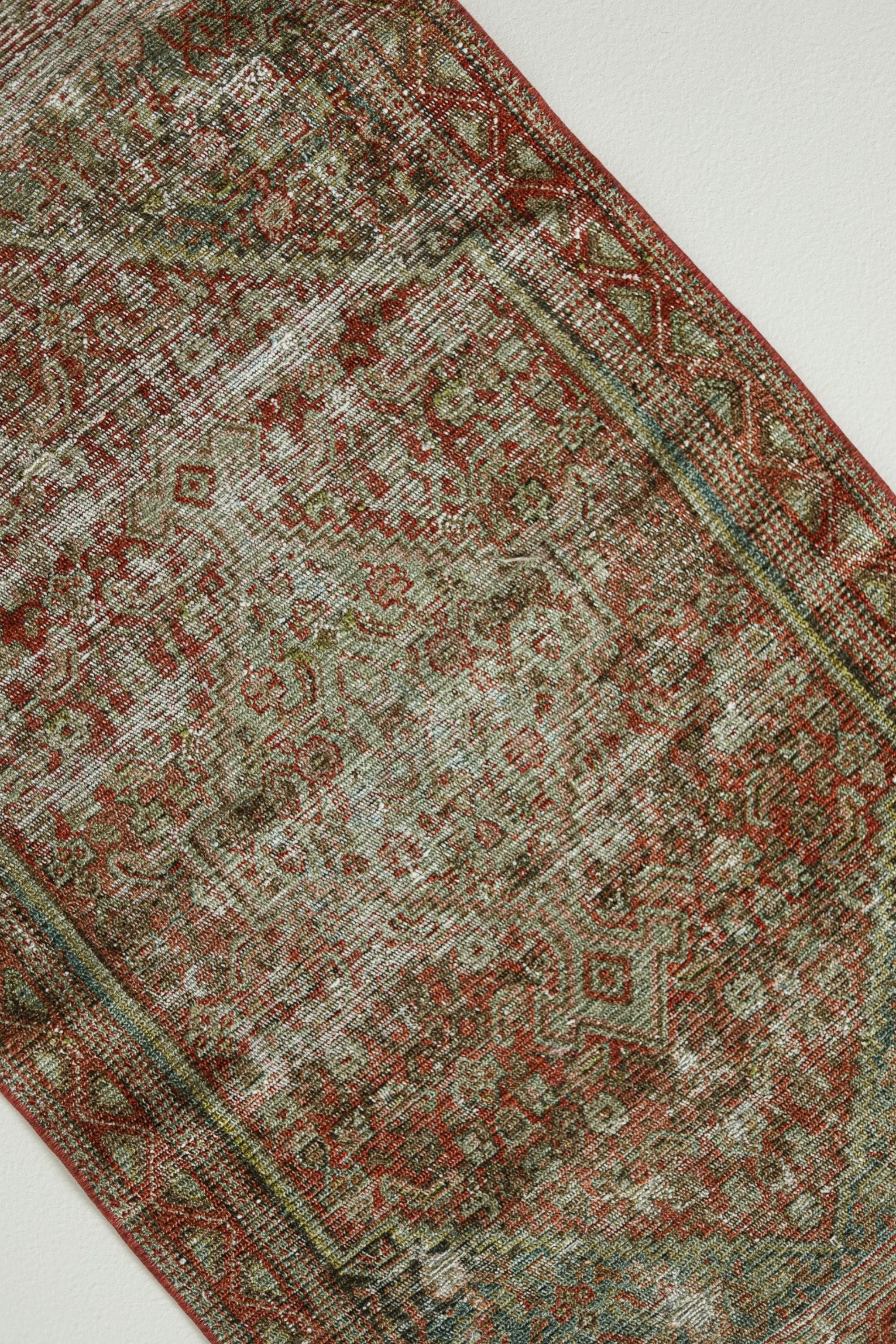a red and green rug on a white floor