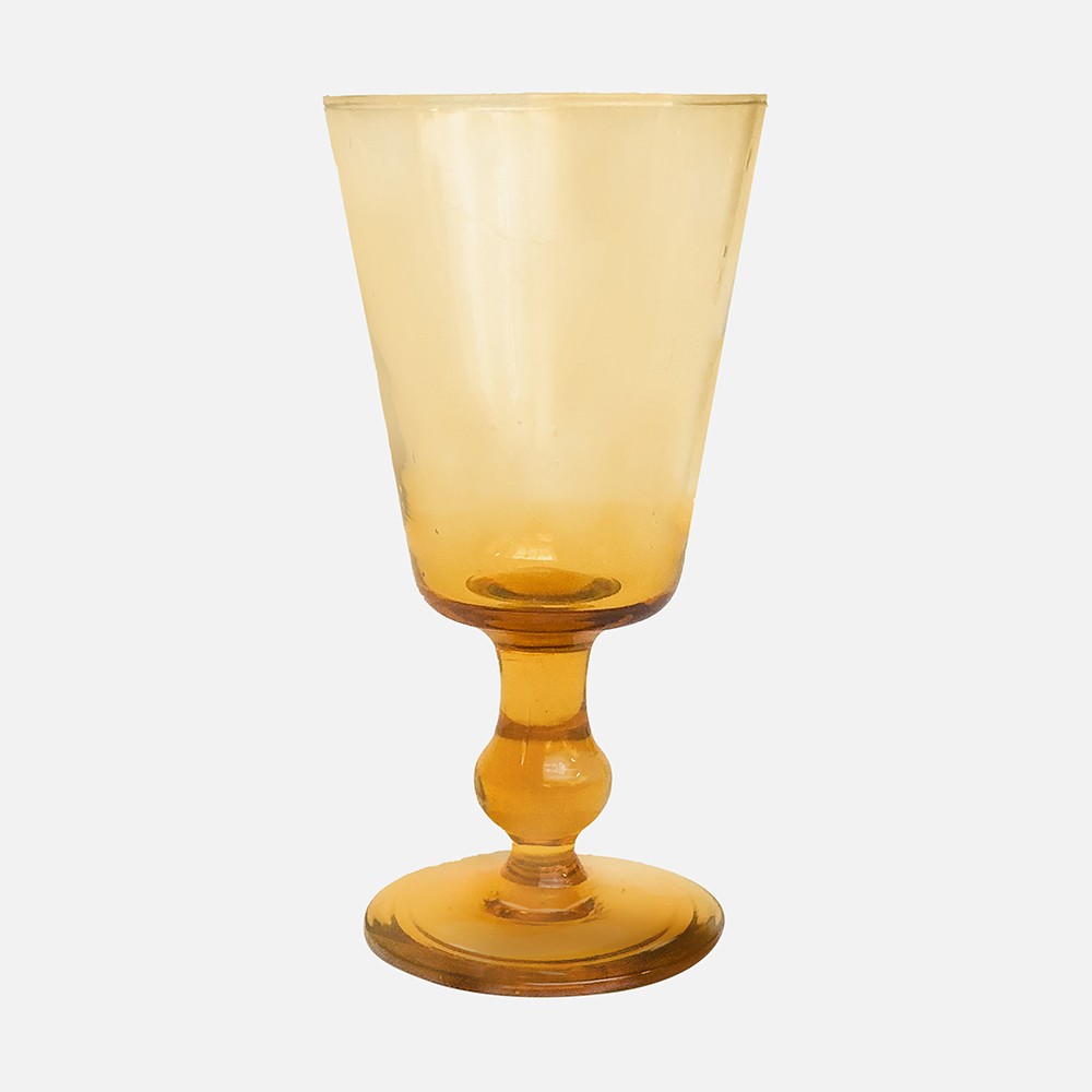 a yellow glass is sitting on a white surface
