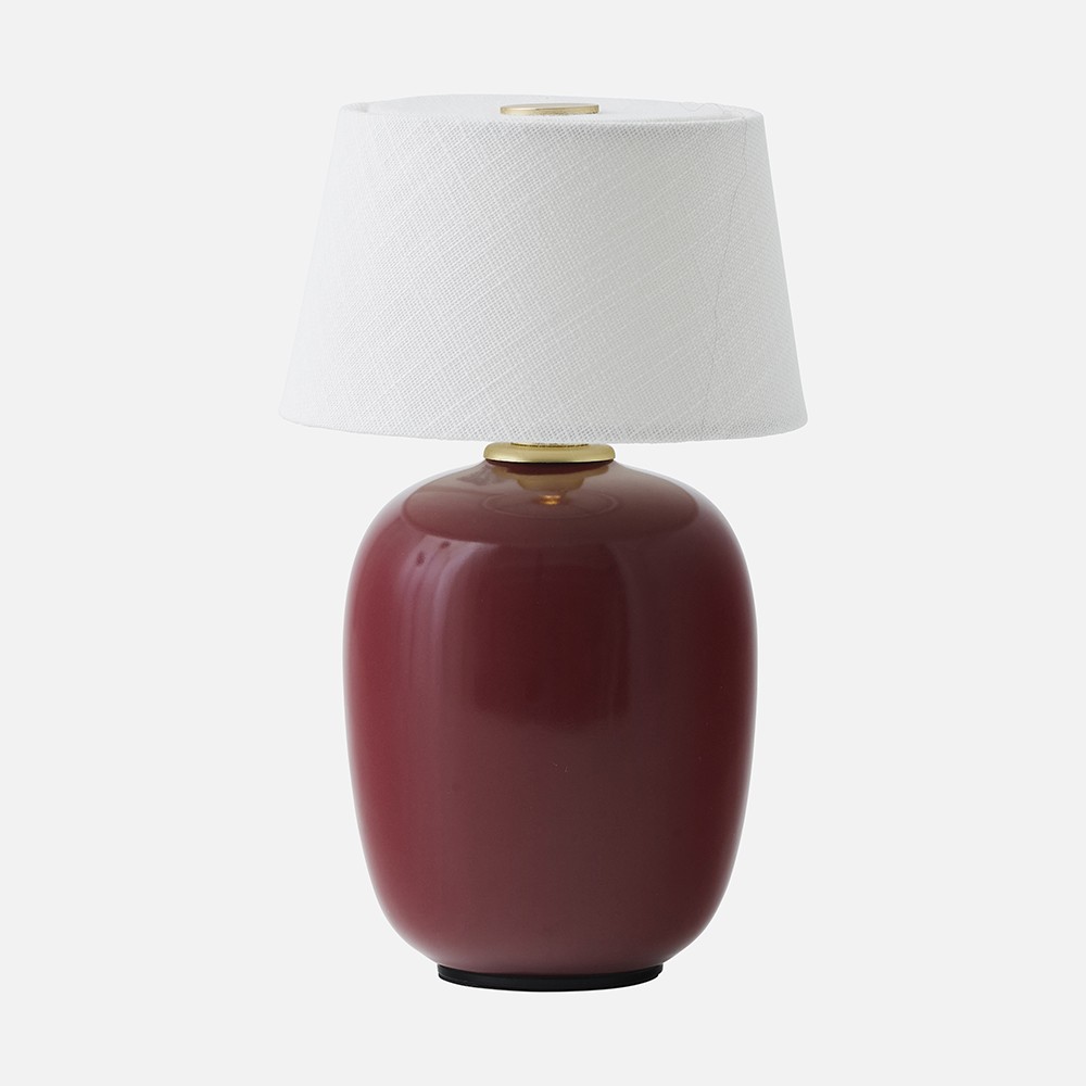 a red table lamp with a white shade