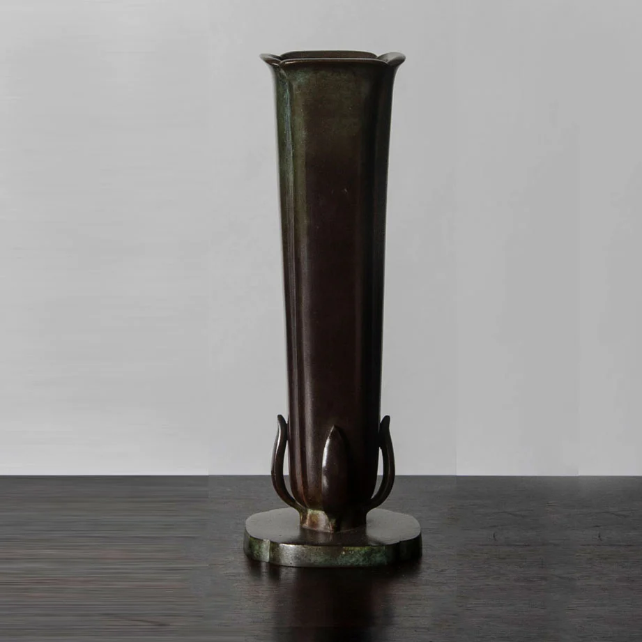 a tall vase sitting on top of a wooden table