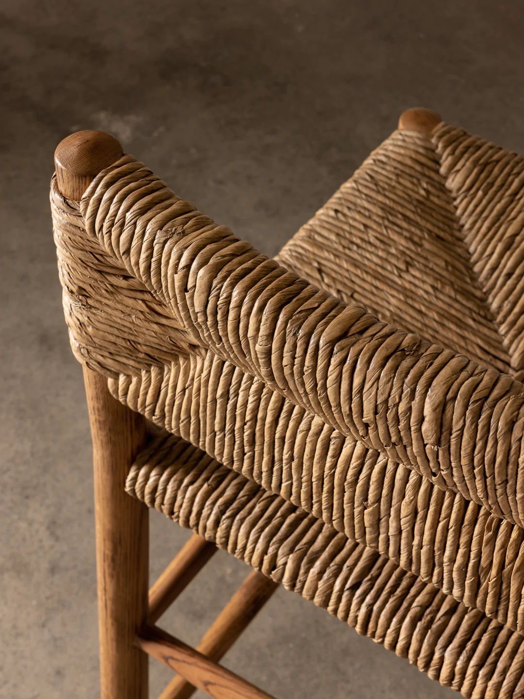 a close up of a wooden chair with a woven seat