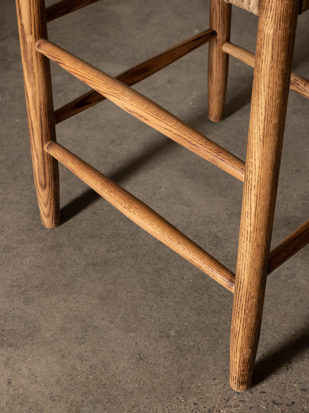 a close up of a wooden stool with a leather seat