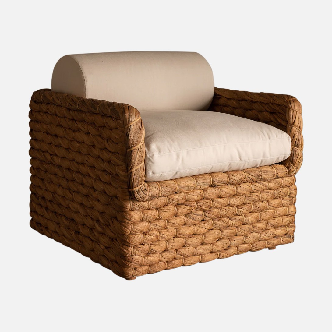 a brown wicker chair with a white cushion
