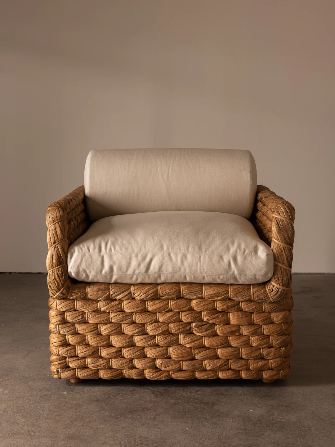 a wicker chair with a cushion on top of it